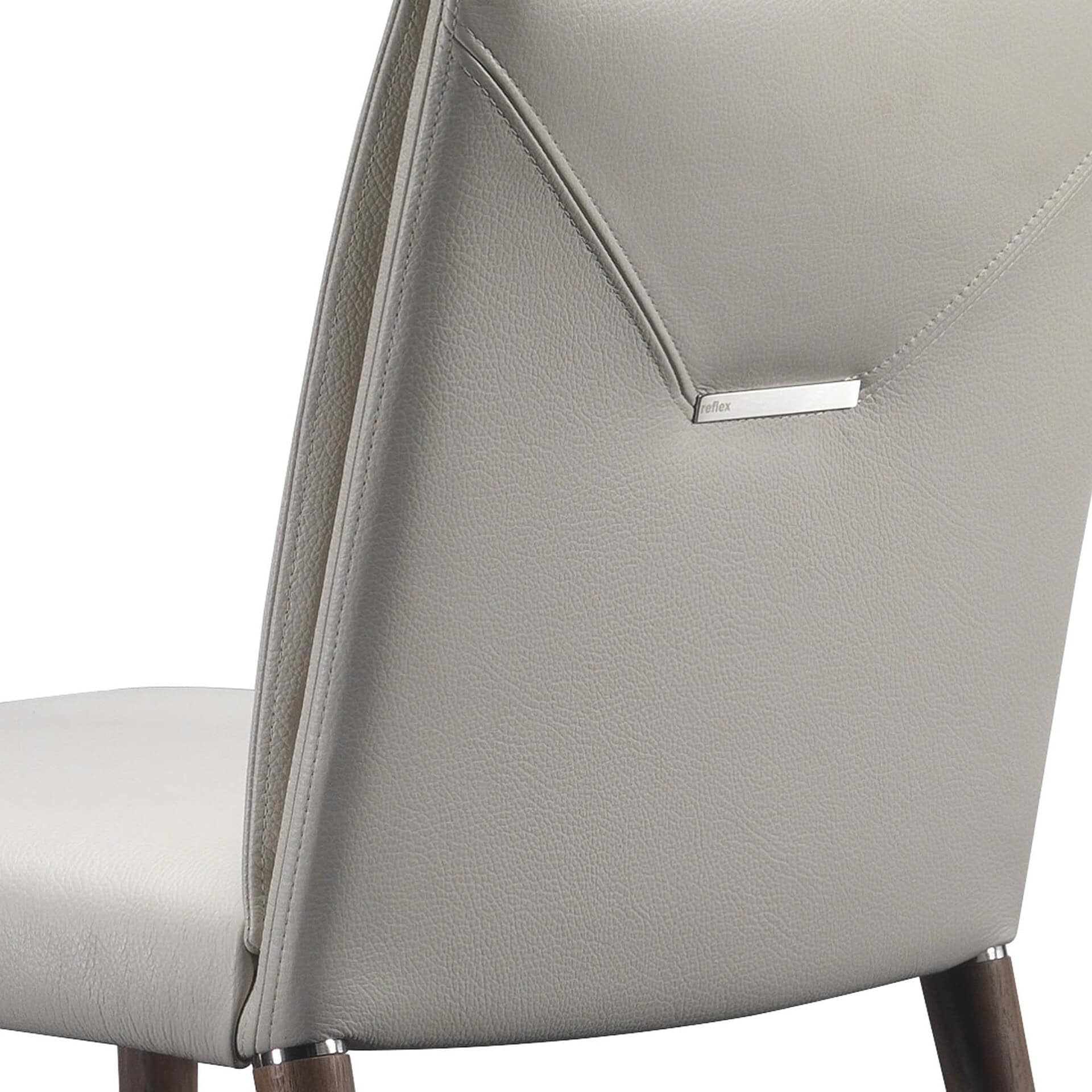 Luxurious beige leather accent chair with modern design and metal details.