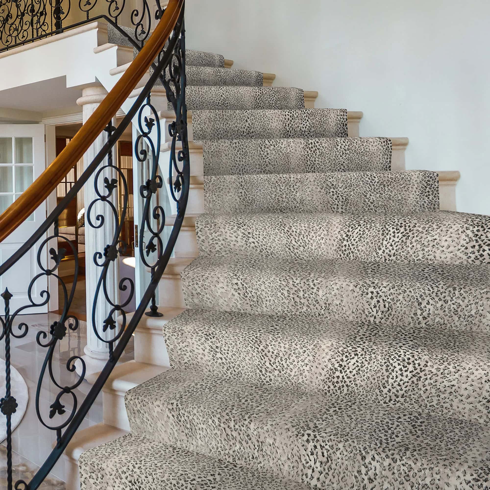Luxury staircase with animal print carpet and ornate black wrought iron railing.