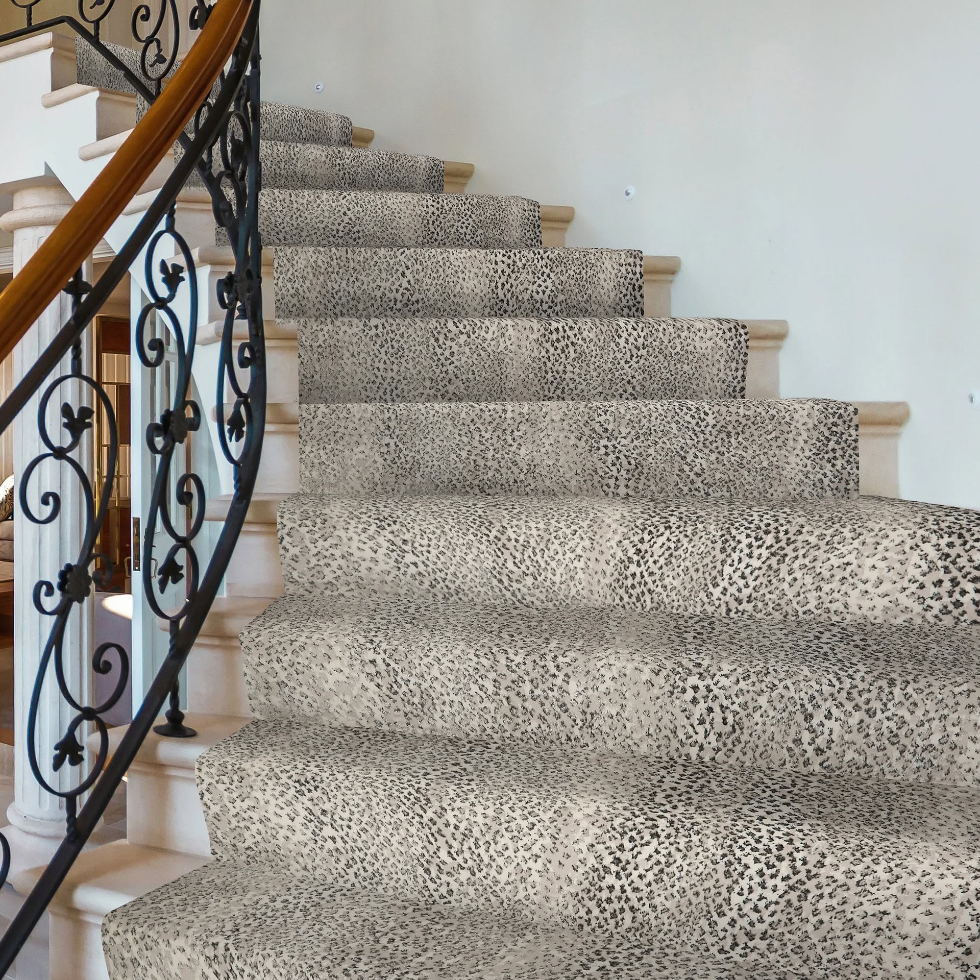 Luxury staircase with animal print carpet and ornate black wrought iron railing.