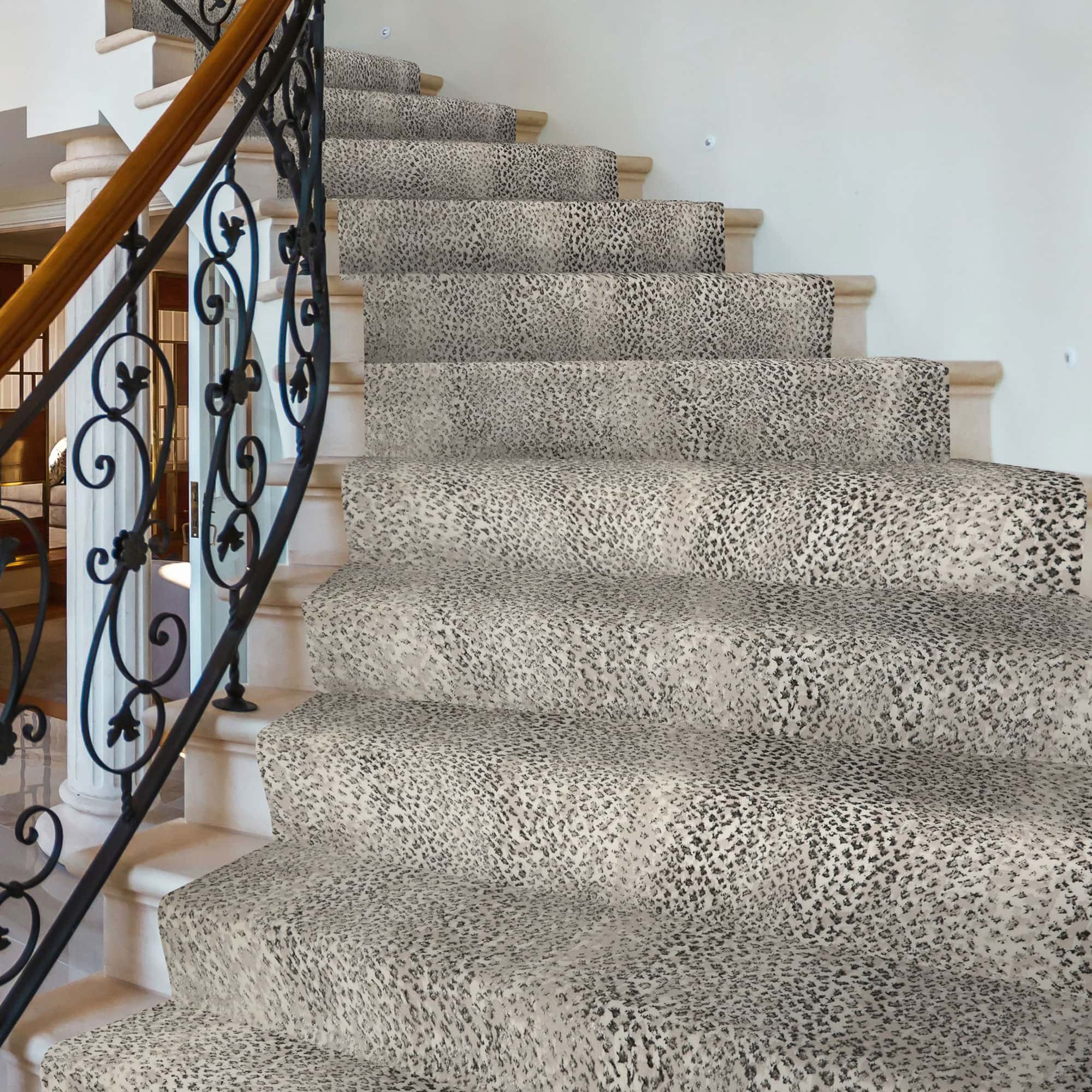 Luxury staircase with animal print carpet and ornate black wrought iron railing.