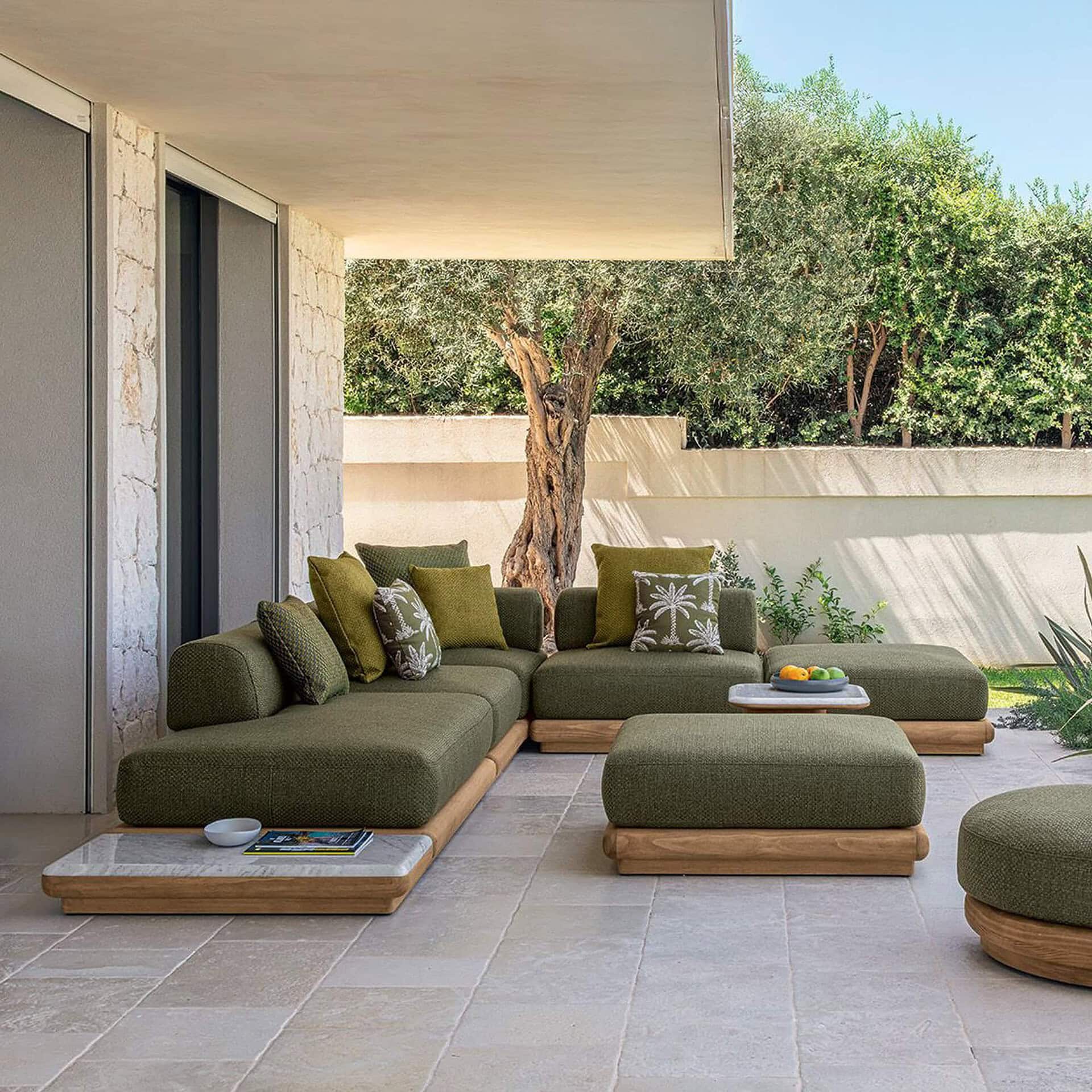 Modern green outdoor sectional sofa with wooden base on patio.