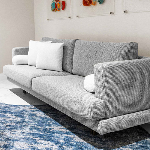 Stylish modern gray fabric sofa with plush cushions for contemporary living rooms.
