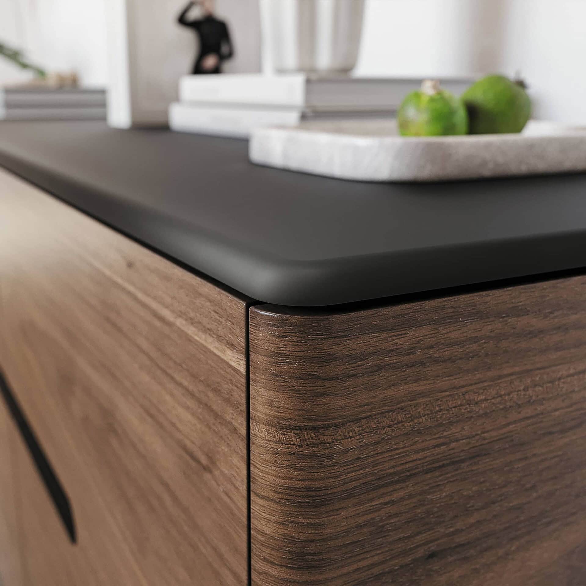 Sleek wooden furniture with modern black accent countertop, showcasing contemporary design and craftsmanship.