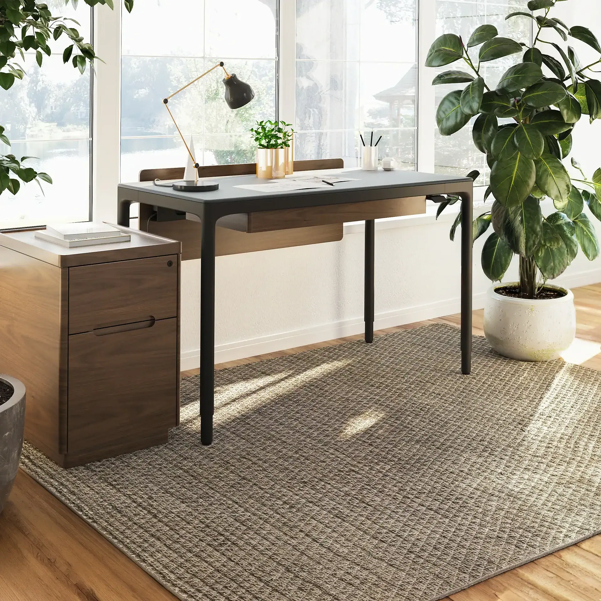Modern white height-adjustable standing desk with a laptop and desk lamp.