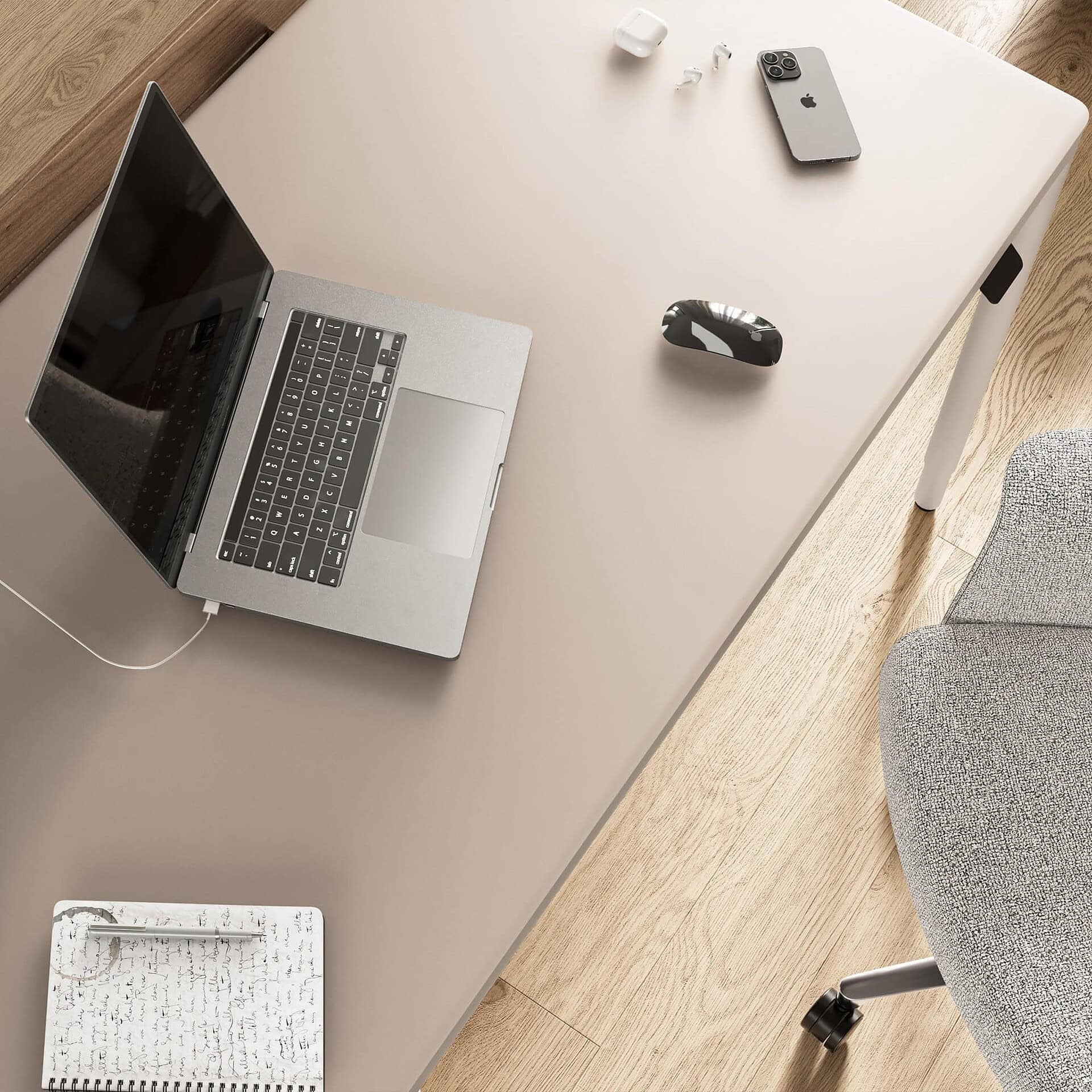 Laptop on a sleek modern white desk with wireless earbuds, iPhone, mouse, and notepad – perfect for contemporary office setups.