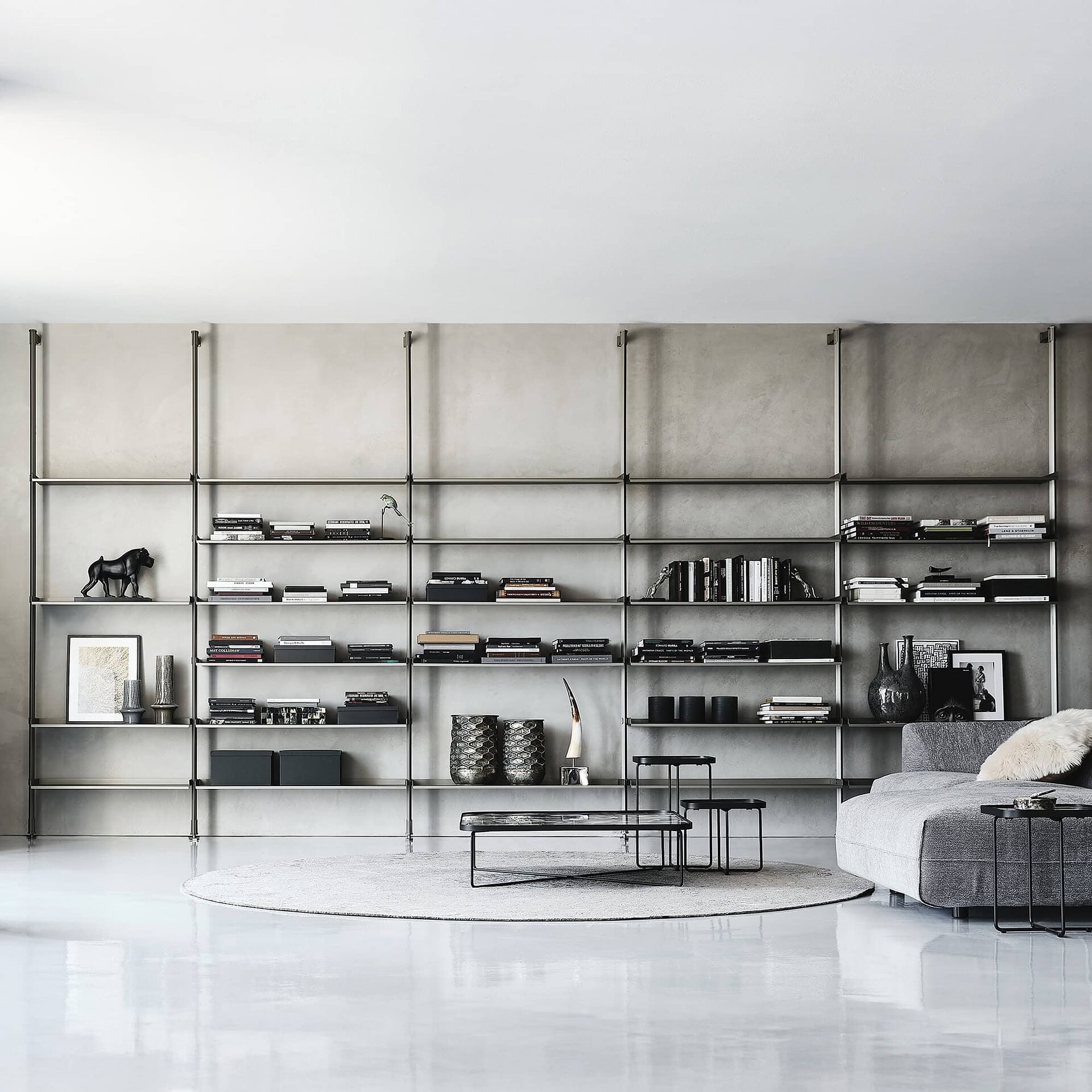 Contemporary living room with modern metallic bookshelf and minimalist decor by Sklar Furnishings.
