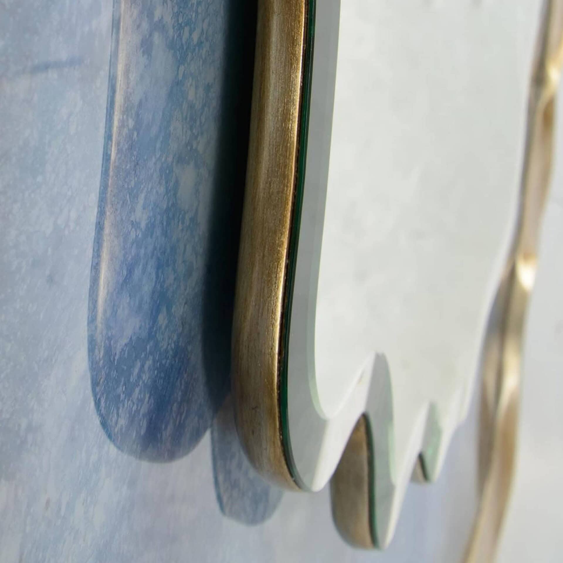 Sleek modern mirror with gold and green accents, stylish decor by Sklar Furnishings.