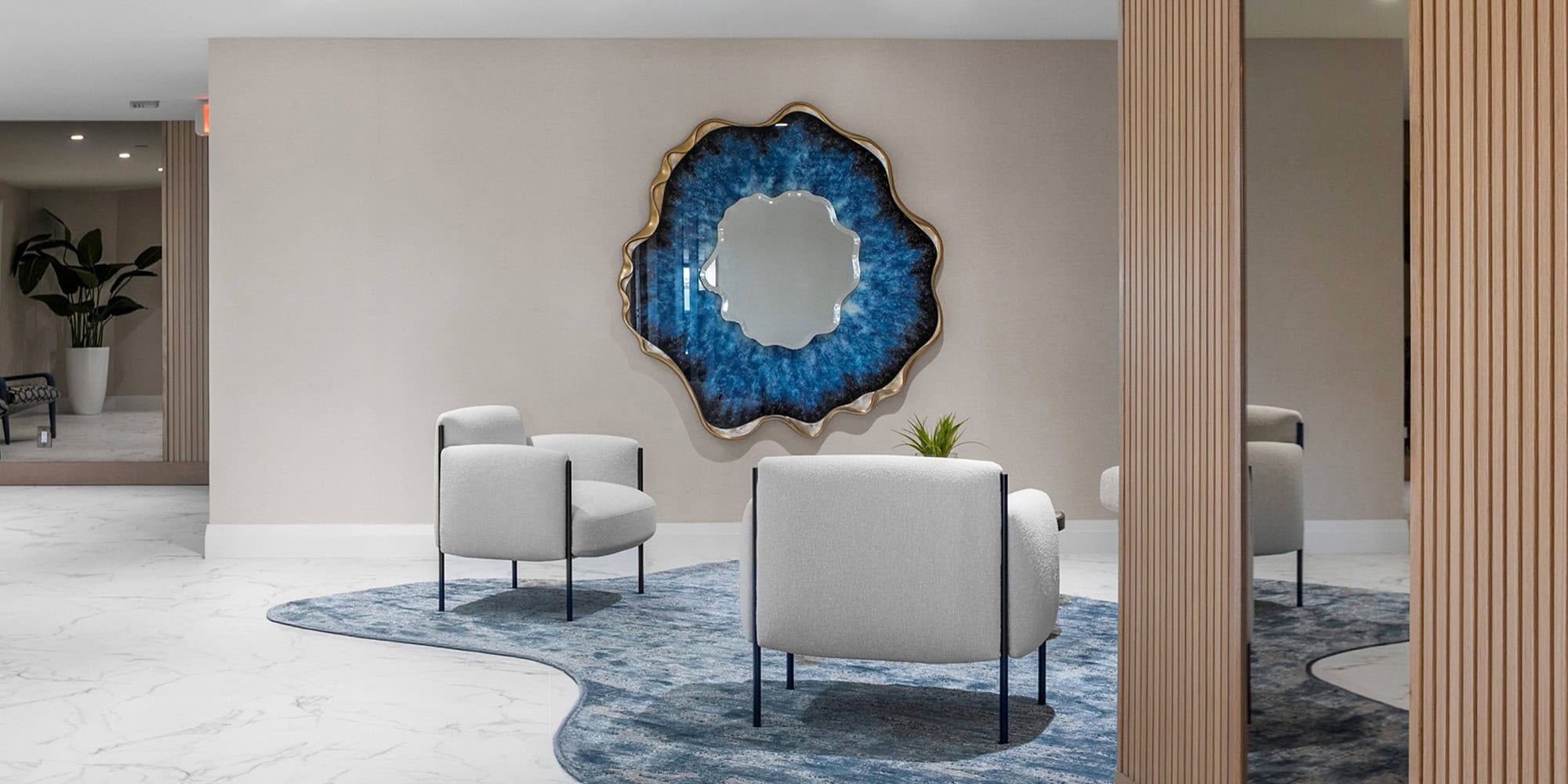 Contemporary living room with modern sofa, white armchairs, decorative wall art, and stylish wooden partitions.