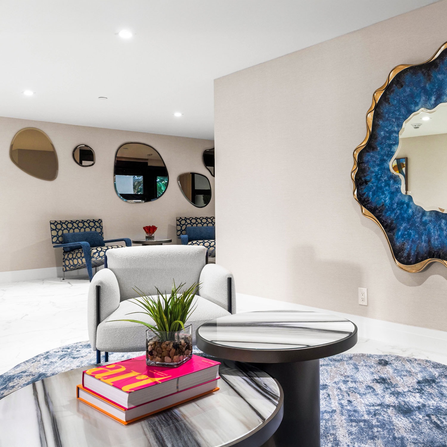 Modern living room with stylish furniture, decorative wall mirrors, and contemporary design elements.