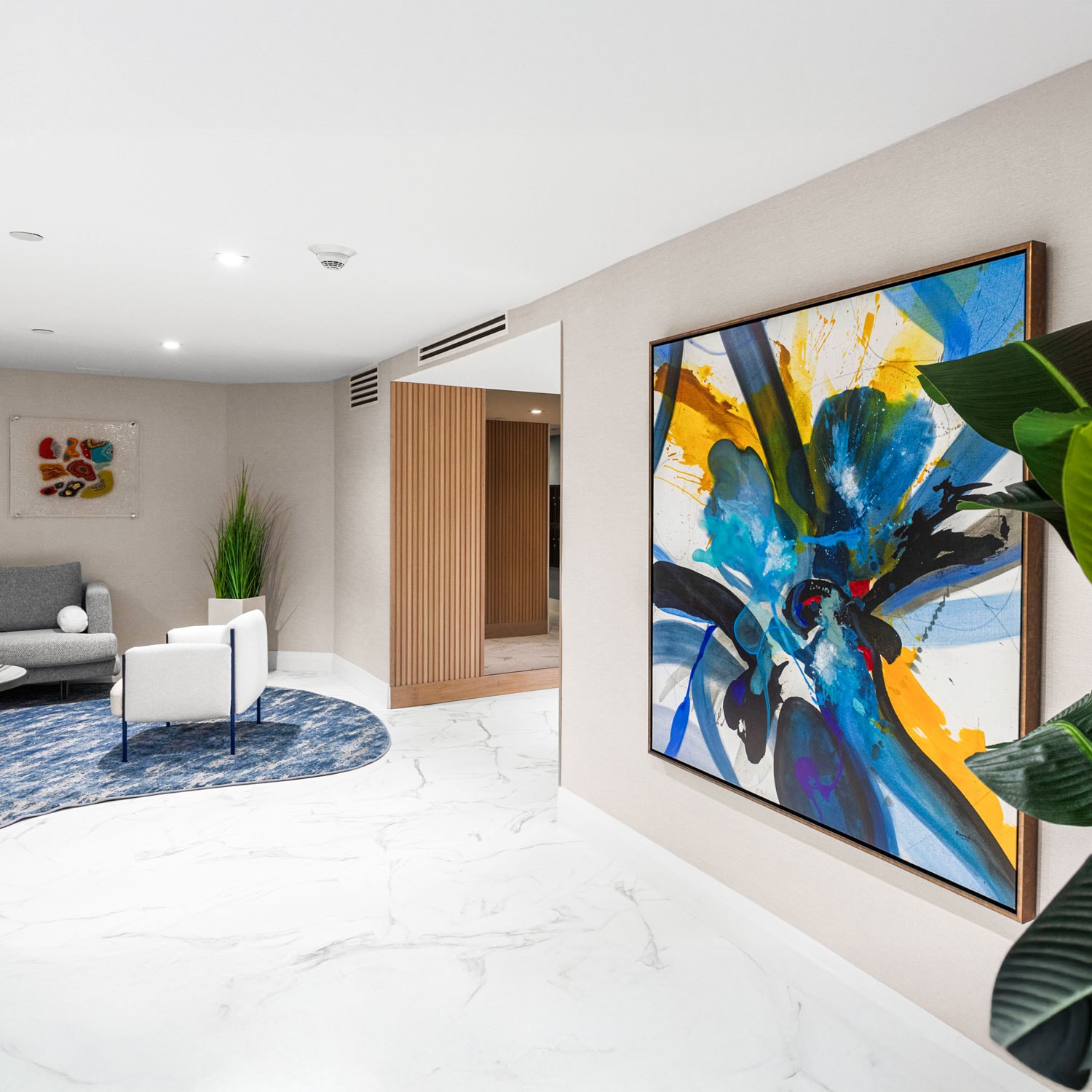 Vivid abstract art in modern lobby with contemporary furniture and marble flooring.