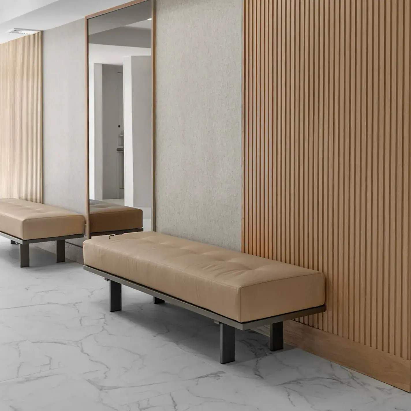 Contemporary lobby seating with beige upholstered benches and wood-paneled accent walls.