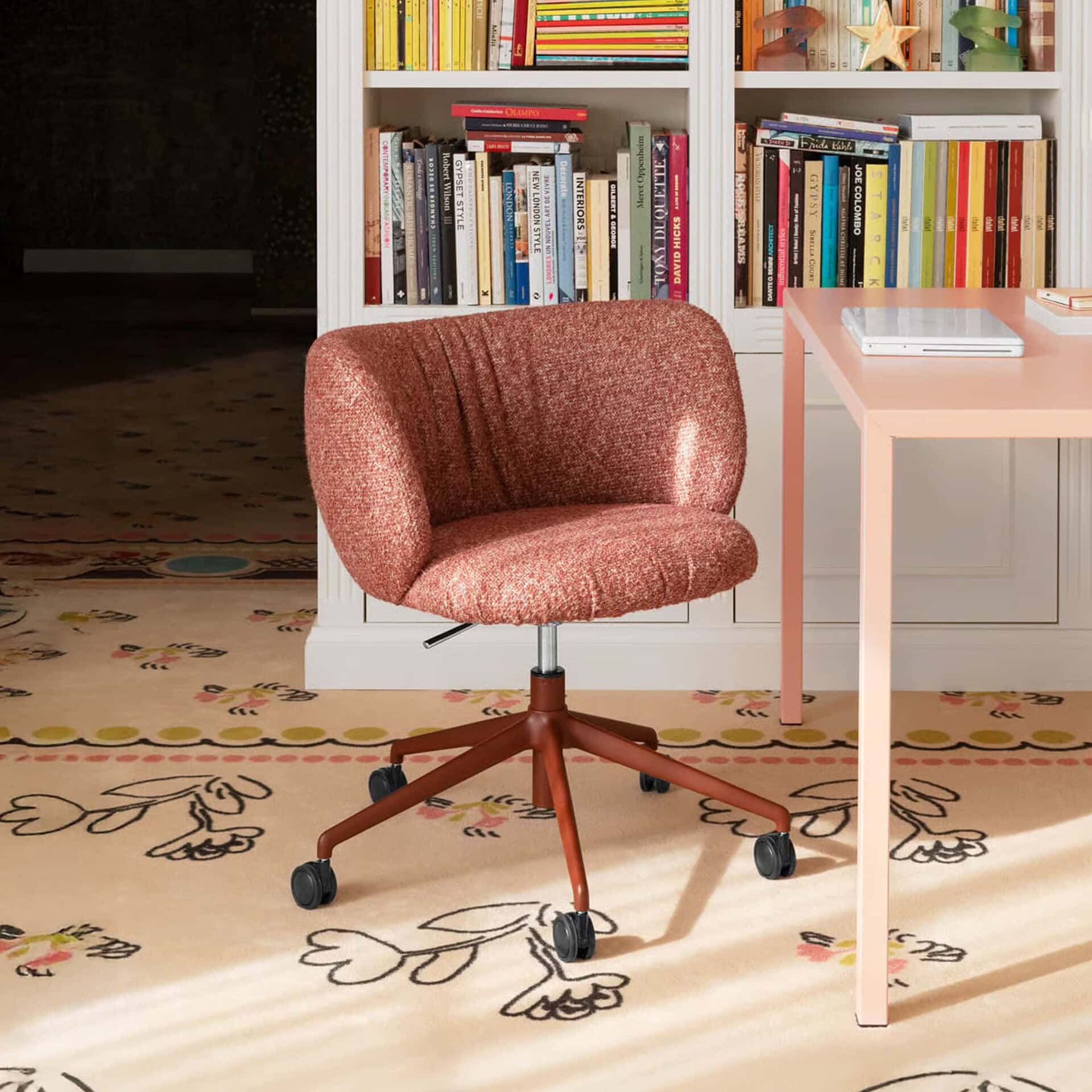 Comfortable pink and brown upholstered office chair with casters in a stylish home workspace.