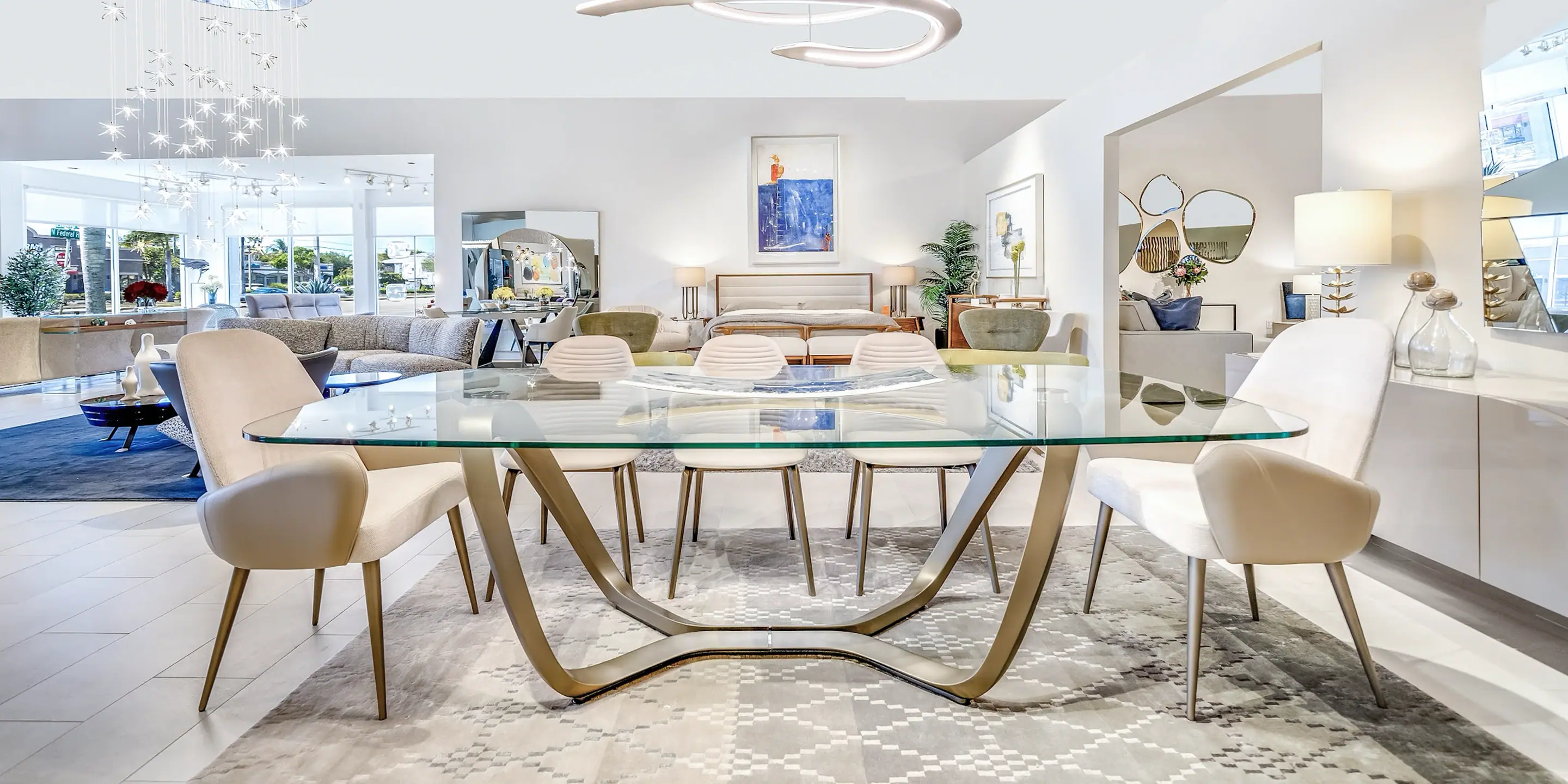 Elegant modern dining room with glass table and designer chairs, showcasing high-end furniture by Sklar Furnishings.
