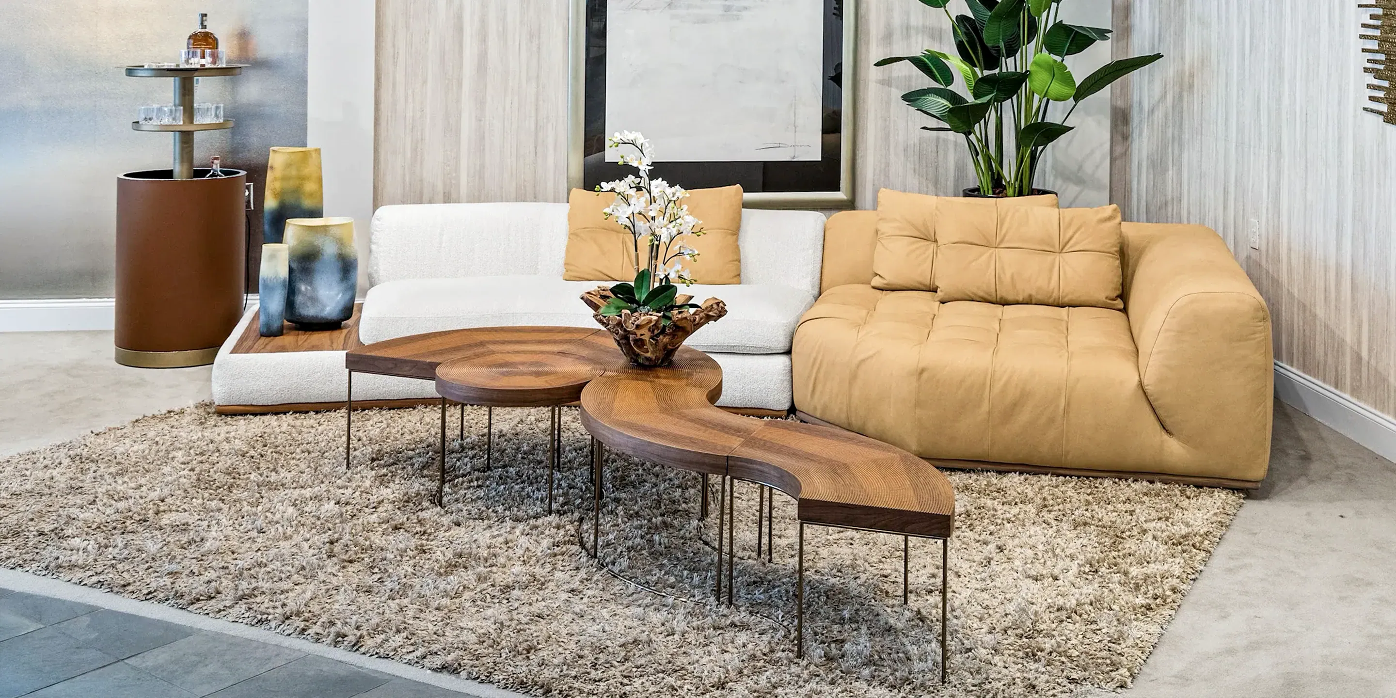 showroom-vignette-jun-26-living-room-6 Modern beige and white sectional sofas with wooden coffee table in contemporary living room setting.