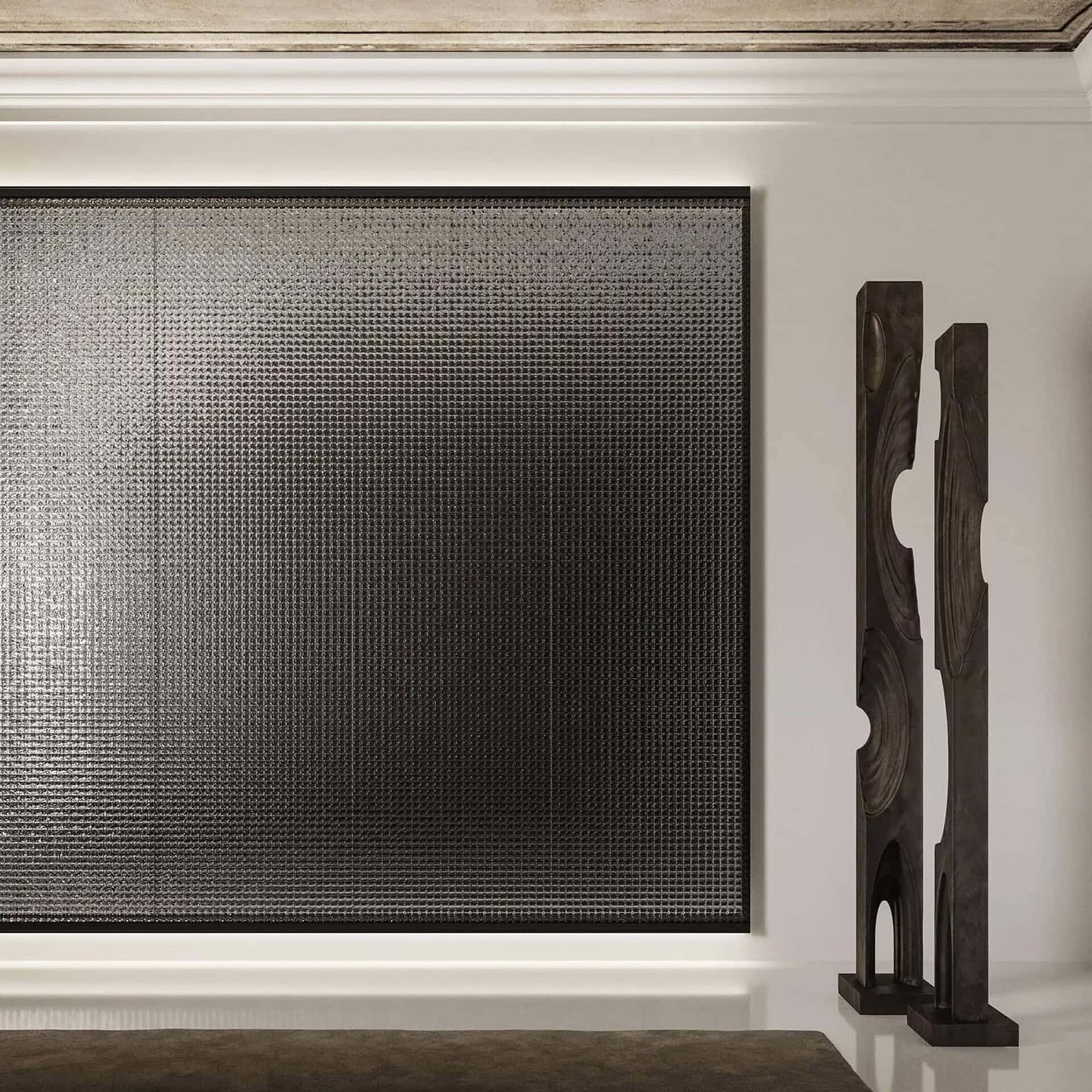 Bright modern interior with textured metal wall art and sleek dark wood sculptures.