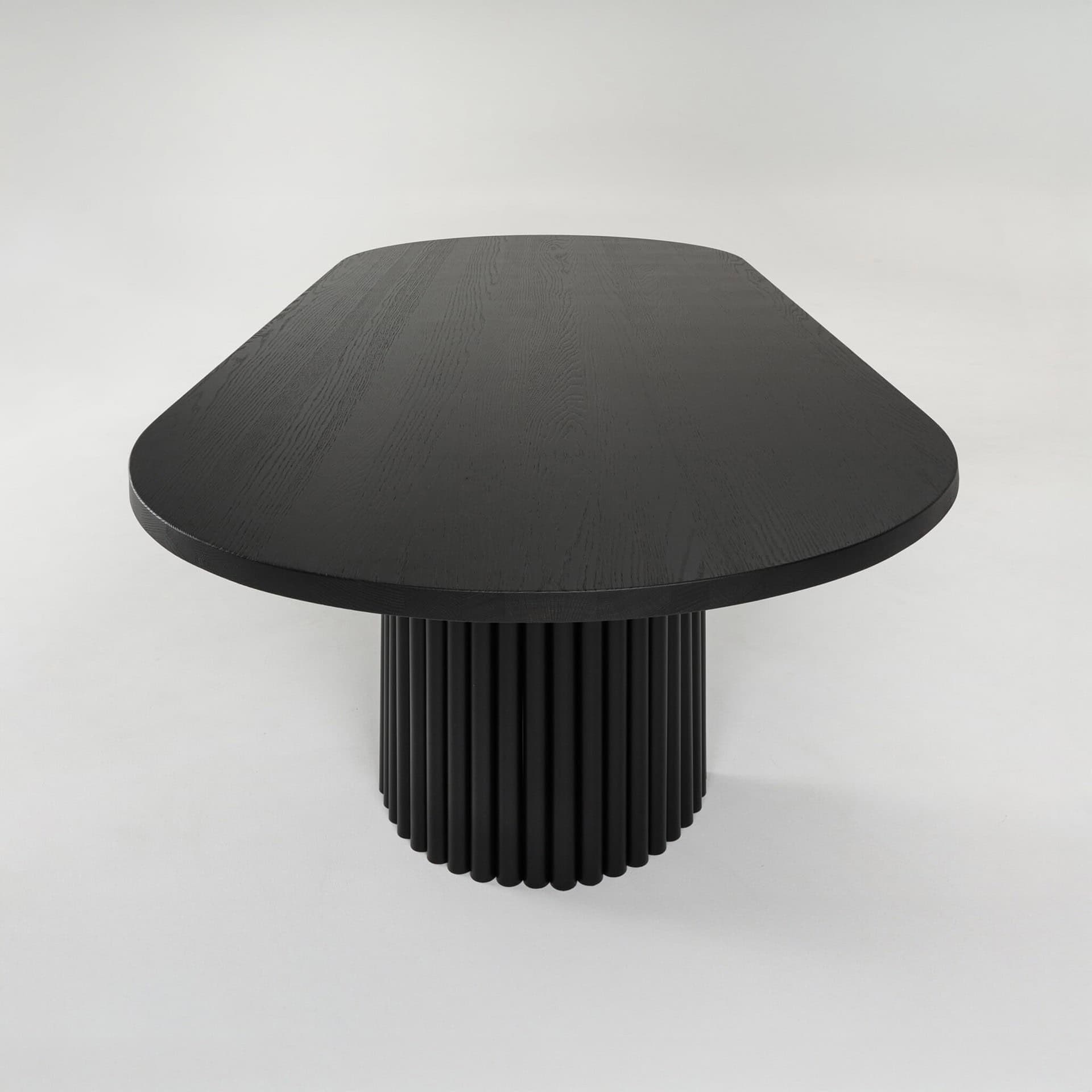 Elegant black wooden dining table with distinctive fluted cylindrical pedestal base for contemporary spaces.