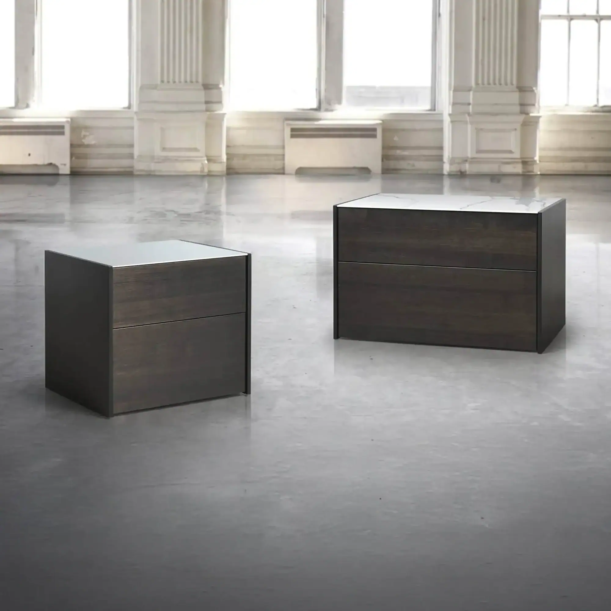 Contemporary dark wood and marble accent tables in a spacious, bright interior setting.