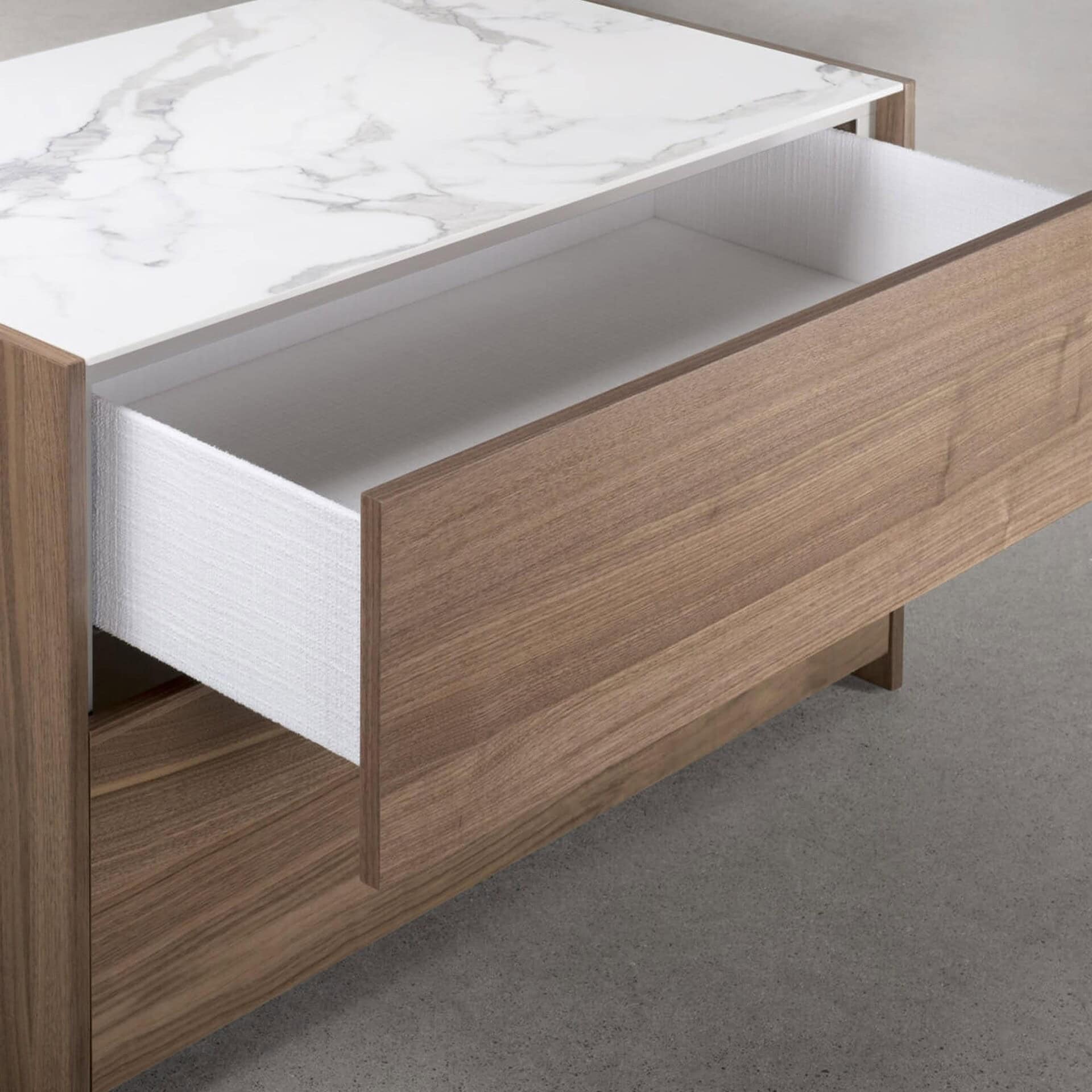 Modern wooden dresser with marble top and open storage drawer for contemporary home decor.