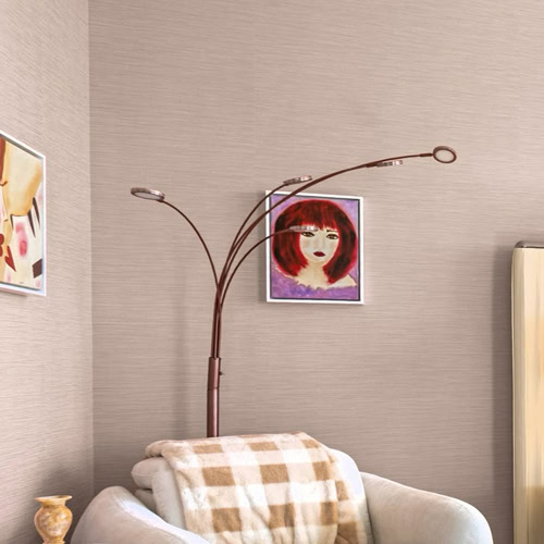 A modern floor lamp with multiple arcing white arms and small lights illuminates a dark wooden wall above a stone shelf with a sculpture and stacked logs.