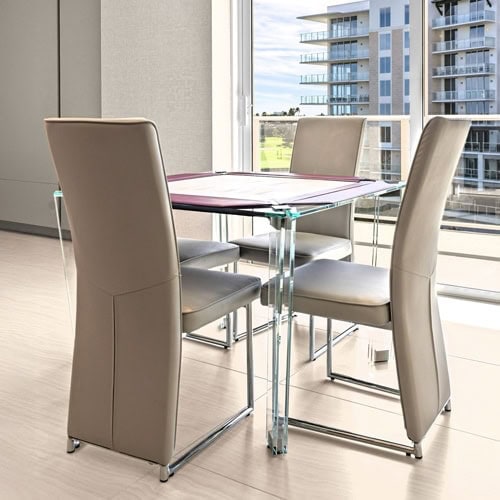 Contemporary glass dining table with beige upholstered chairs in a stylish condo setting.