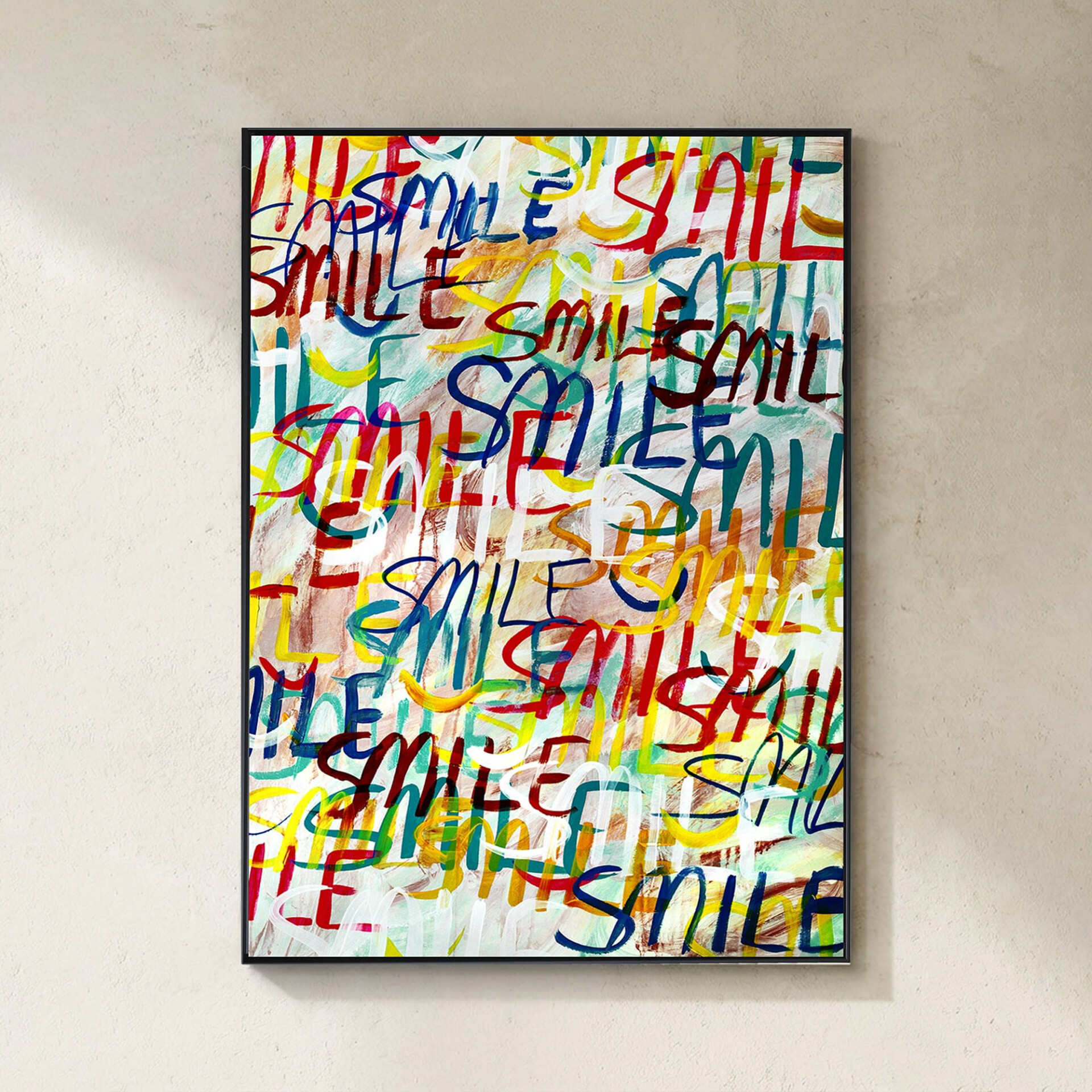 A framed abstract artwork featuring the word 'SMILE' repeated in vibrant red, blue, yellow, green, and white brushstrokes, hanging on a light beige wall.