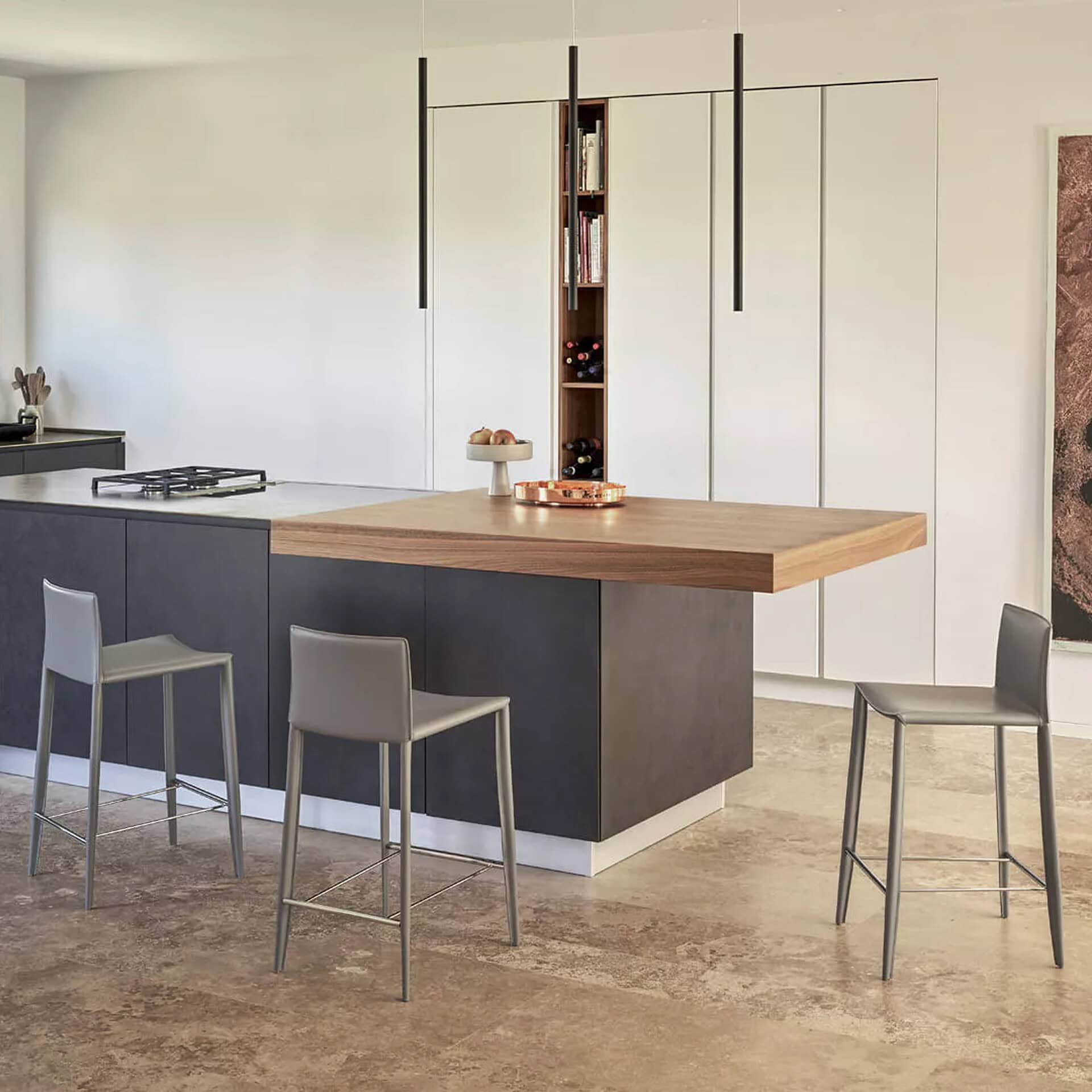 Contemporary kitchen with sleek island, black base, wooden countertop, metallic stools, and minimalist cabinetry.