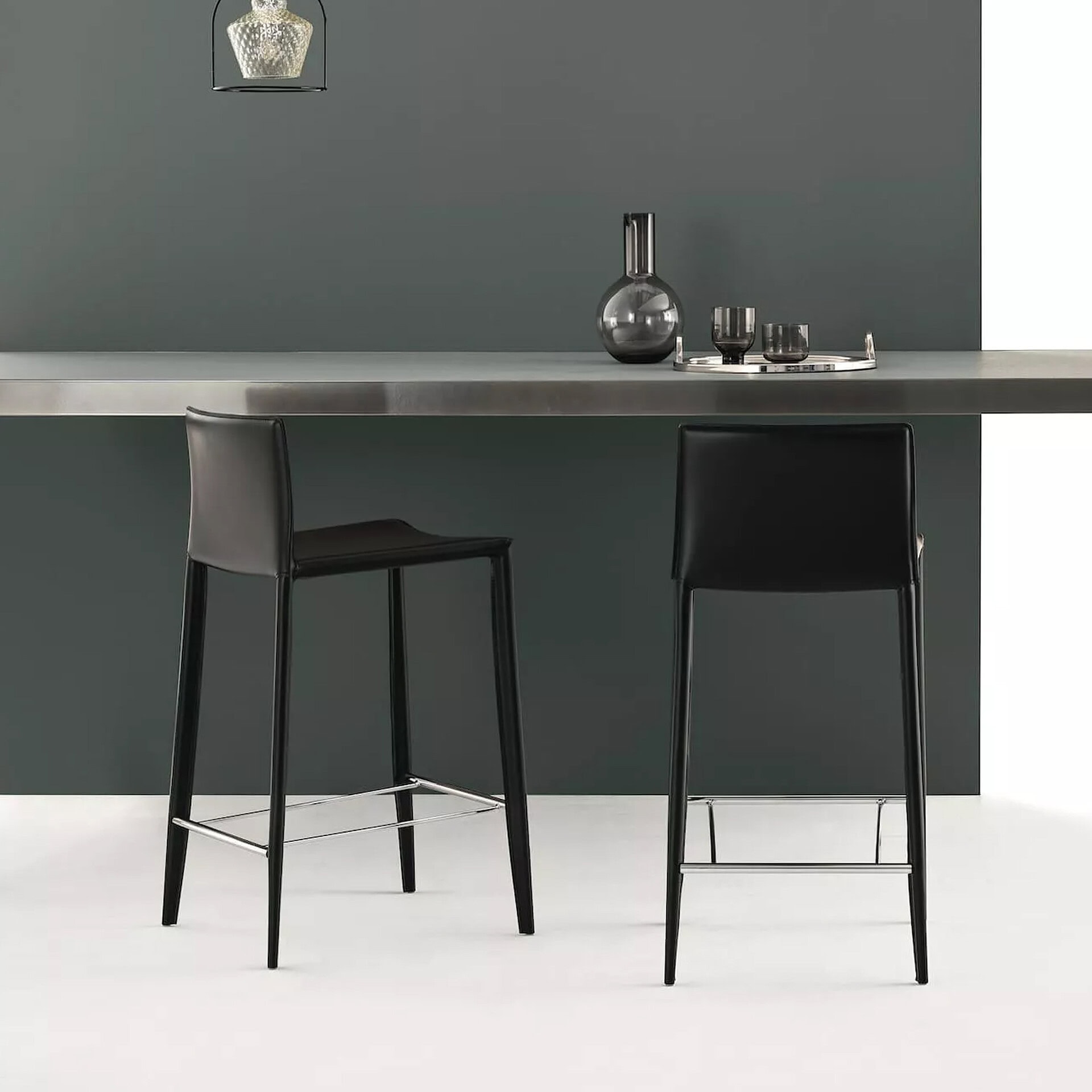 Elegant black bar chairs with metal legs complement contemporary kitchen design.