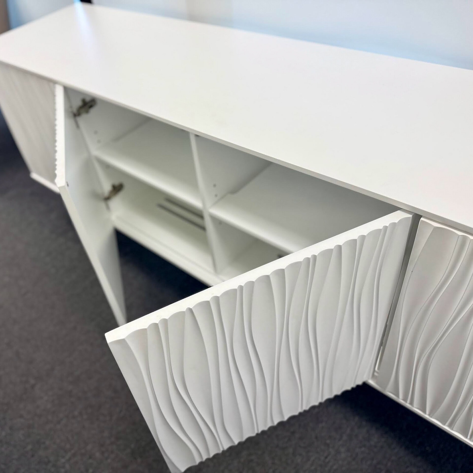 Stylish white storage console featuring textured front design, perfect for contemporary interiors.