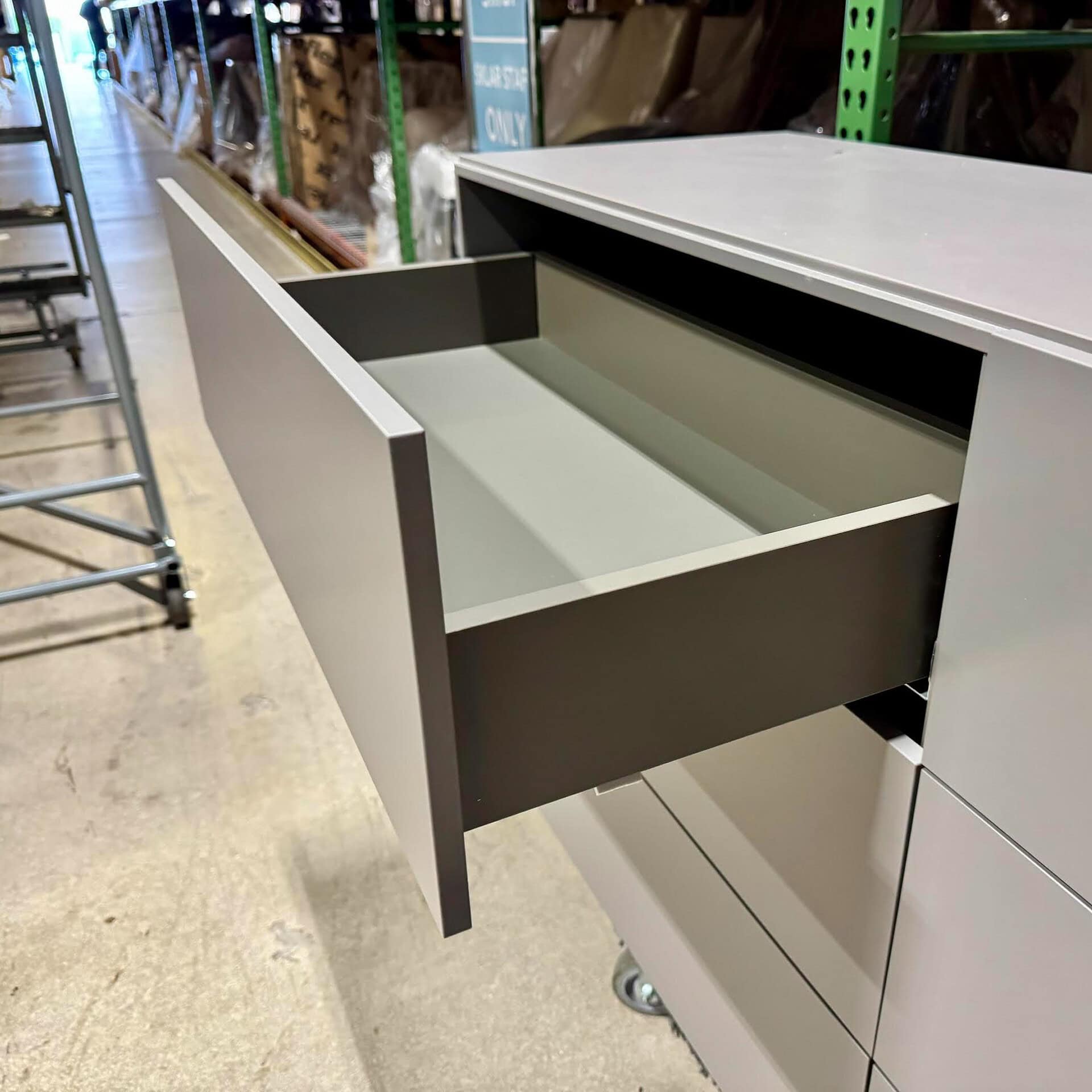 Stylish contemporary gray storage cabinet with spacious open drawer for versatile organization.