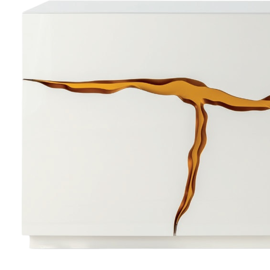 A white surface with a prominent, irregular golden line resembling a Kintsugi-style crack or inlay, branching downwards.