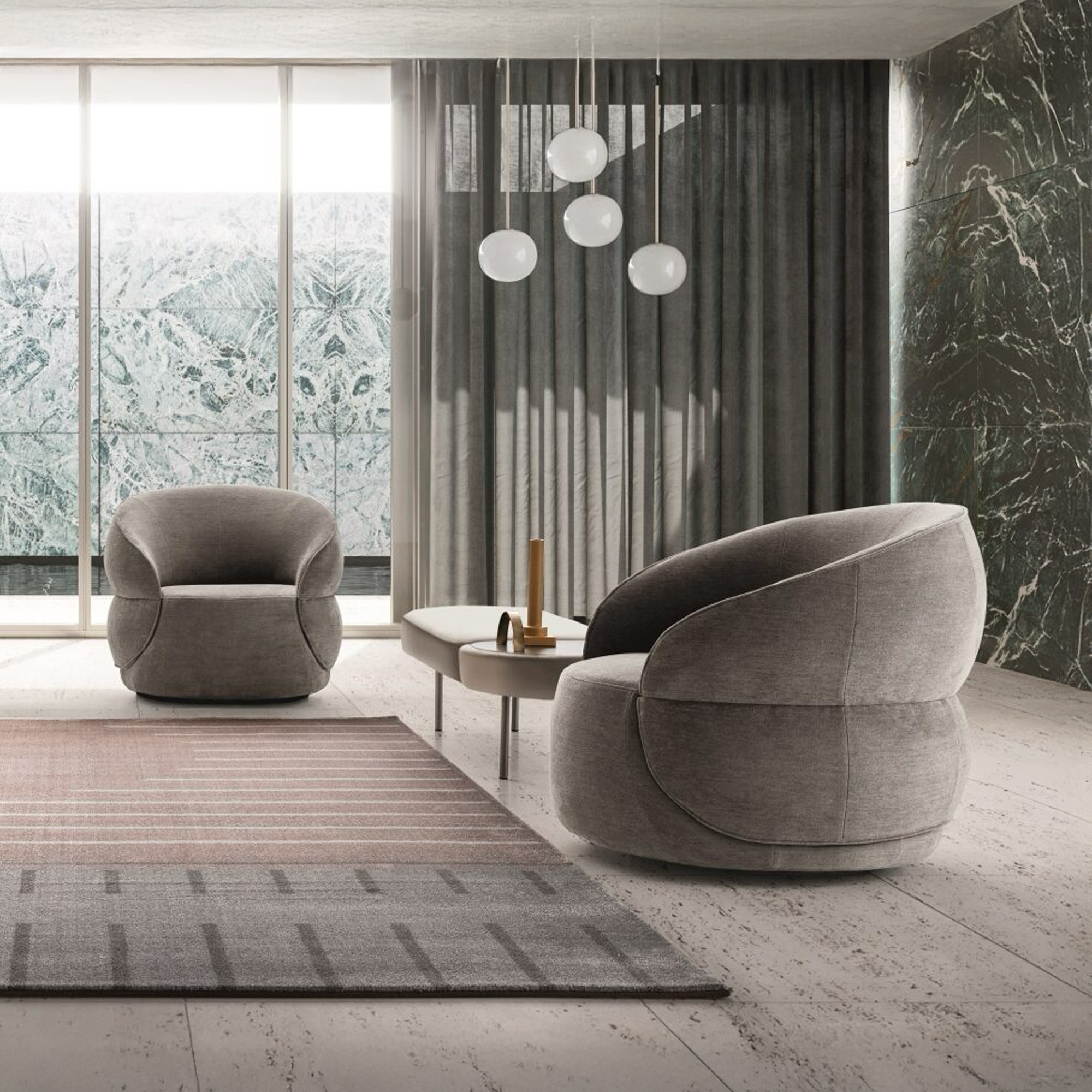 A modern living room with two grey rounded armchairs, a low coffee table, and four spherical pendant lights. The room features a dark marble accent wall, large windows with a marble-patterned view, and a grey and pink geometric rug on light tiled floors.