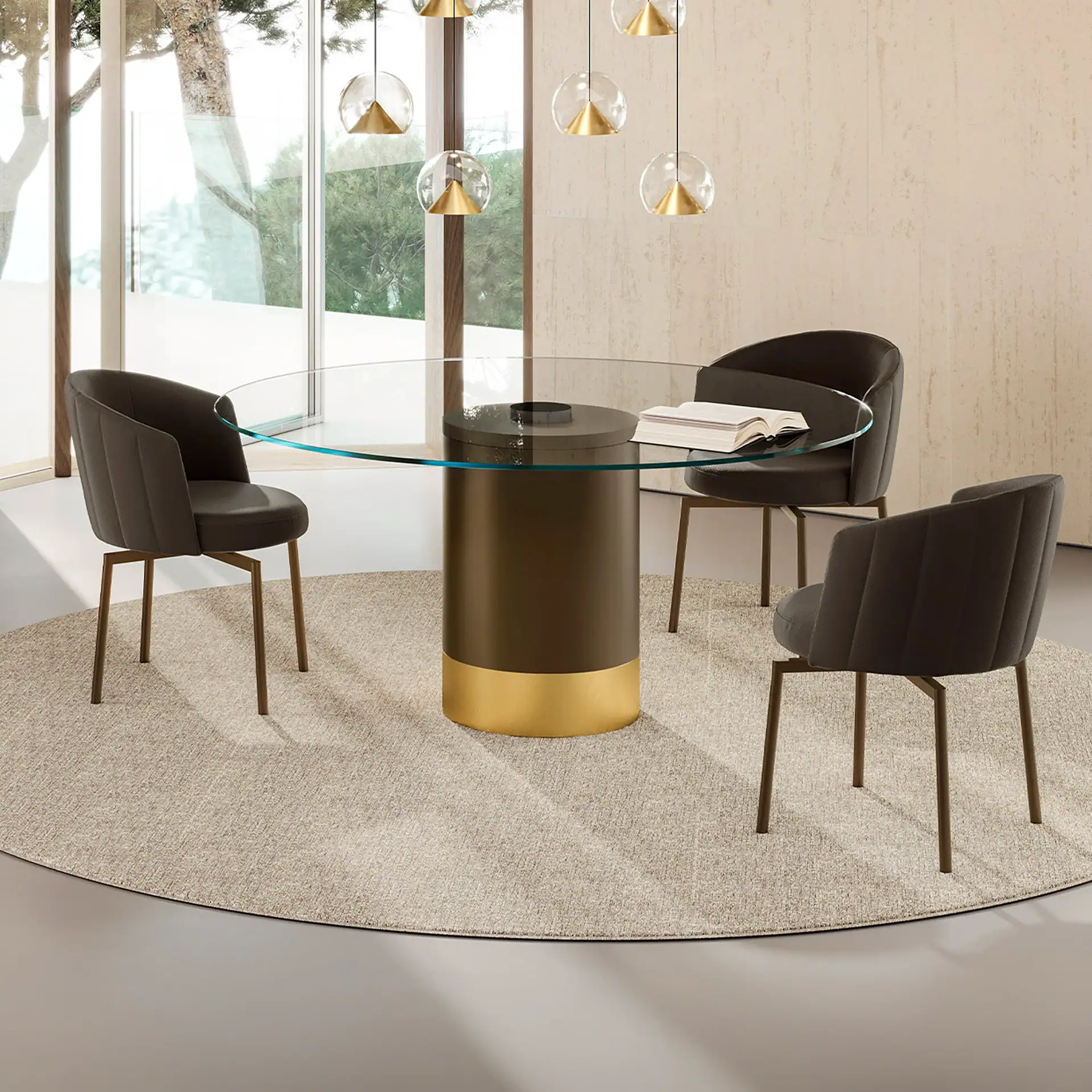Cilindro modern dining table with black and gold base and glass top in a bright room.