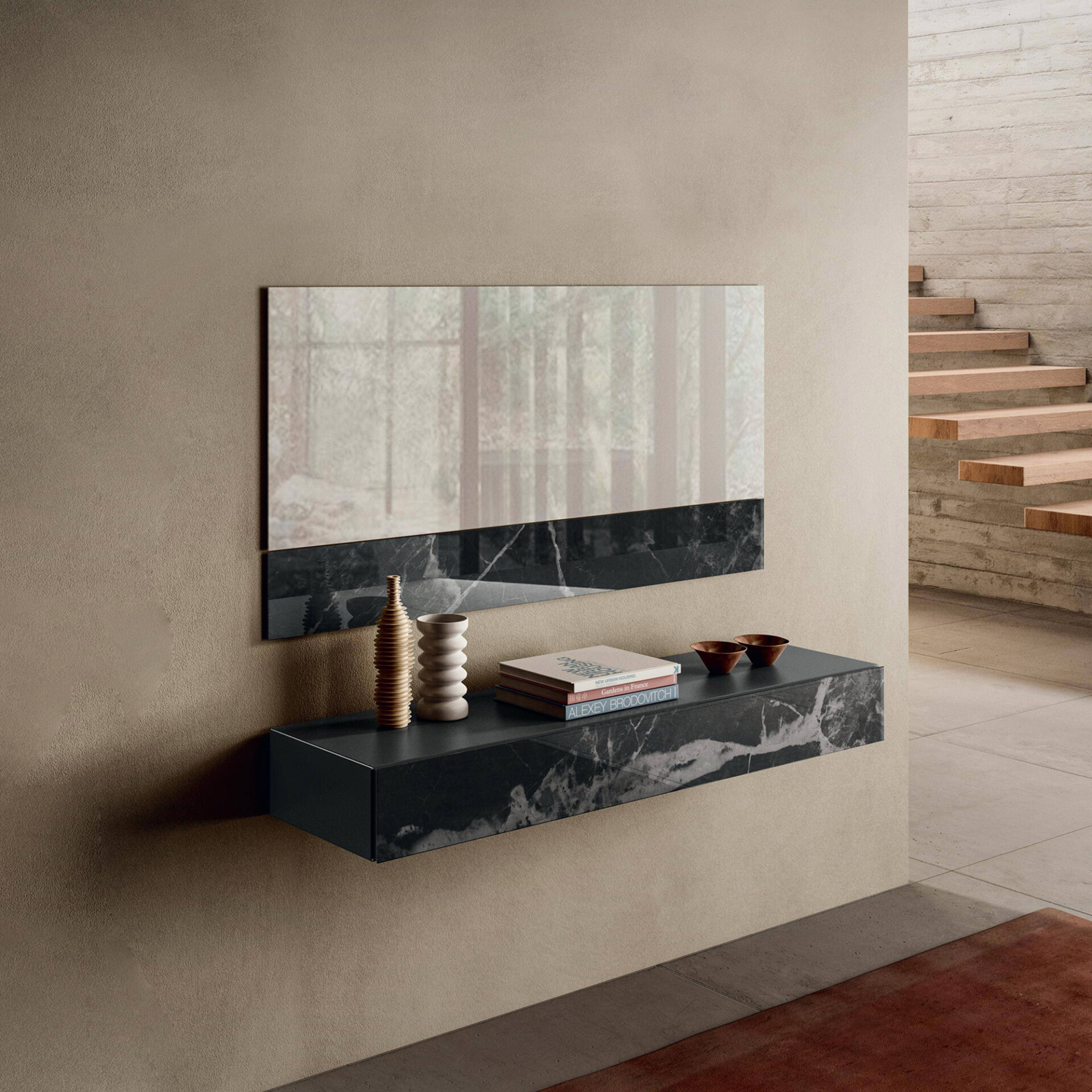 A modern floating black marble console and mirror with minimalist decor against a textured beige wall, next to a concrete wall with a floating wooden staircase.