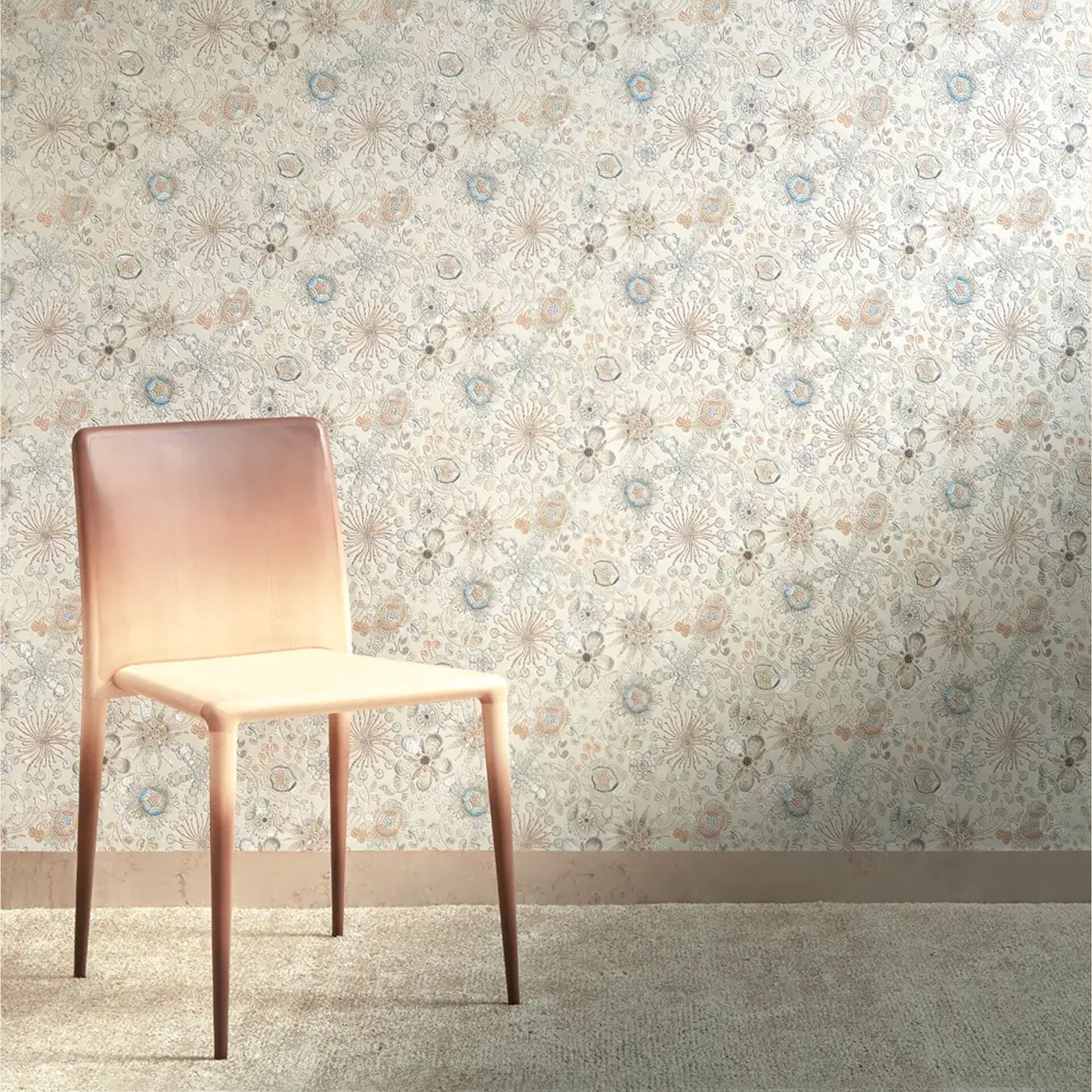 A modern gradient chair, transitioning from light beige to reddish-brown, stands against a wall with intricate floral and botanical wallpaper in muted tones. A shaggy beige carpet covers the floor.