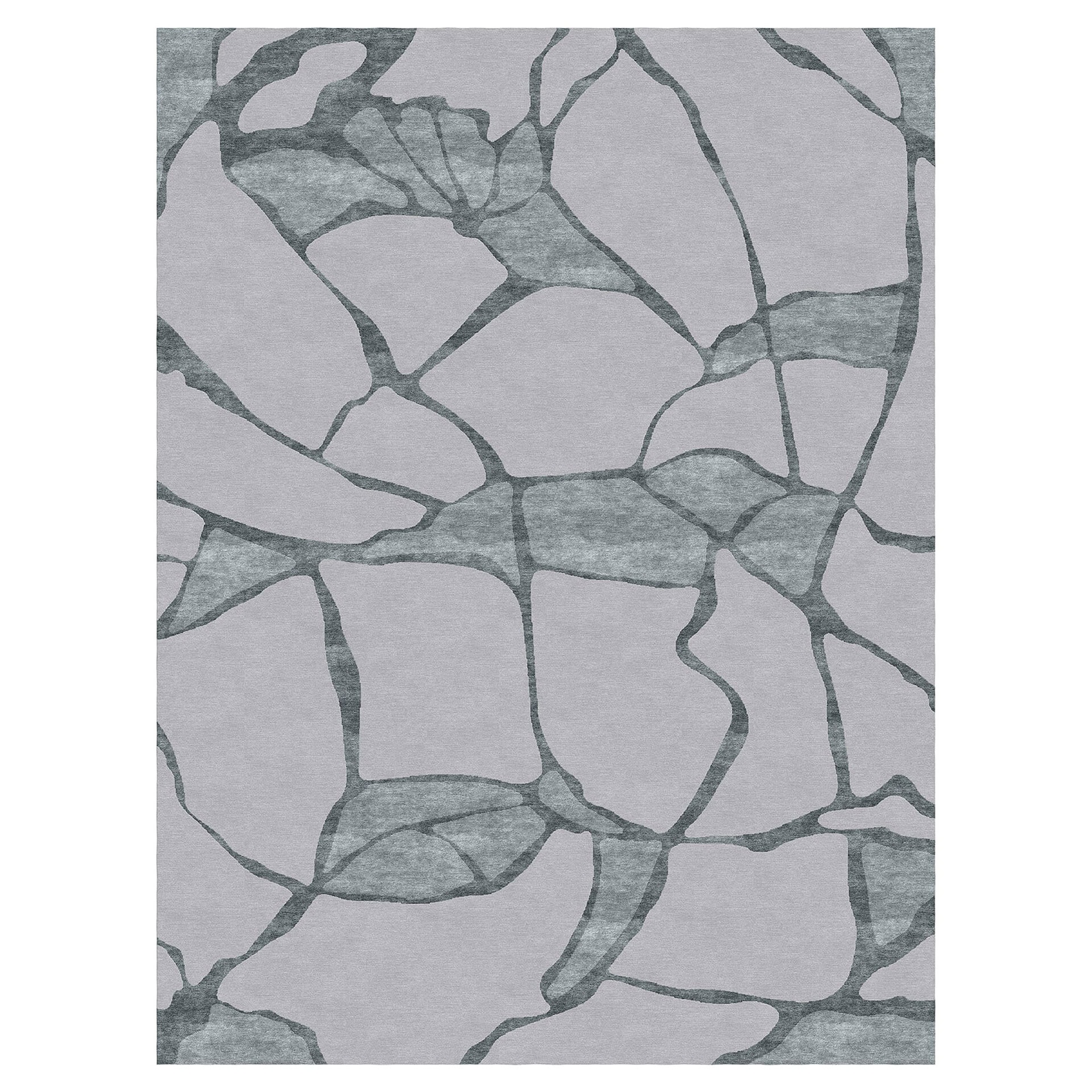 A rectangular area rug with an abstract, organic pattern. It features irregular, vein-like shapes and larger patches in dark teal and blue-green against a light lavender-gray background, resembling cracked earth or a mosaic.