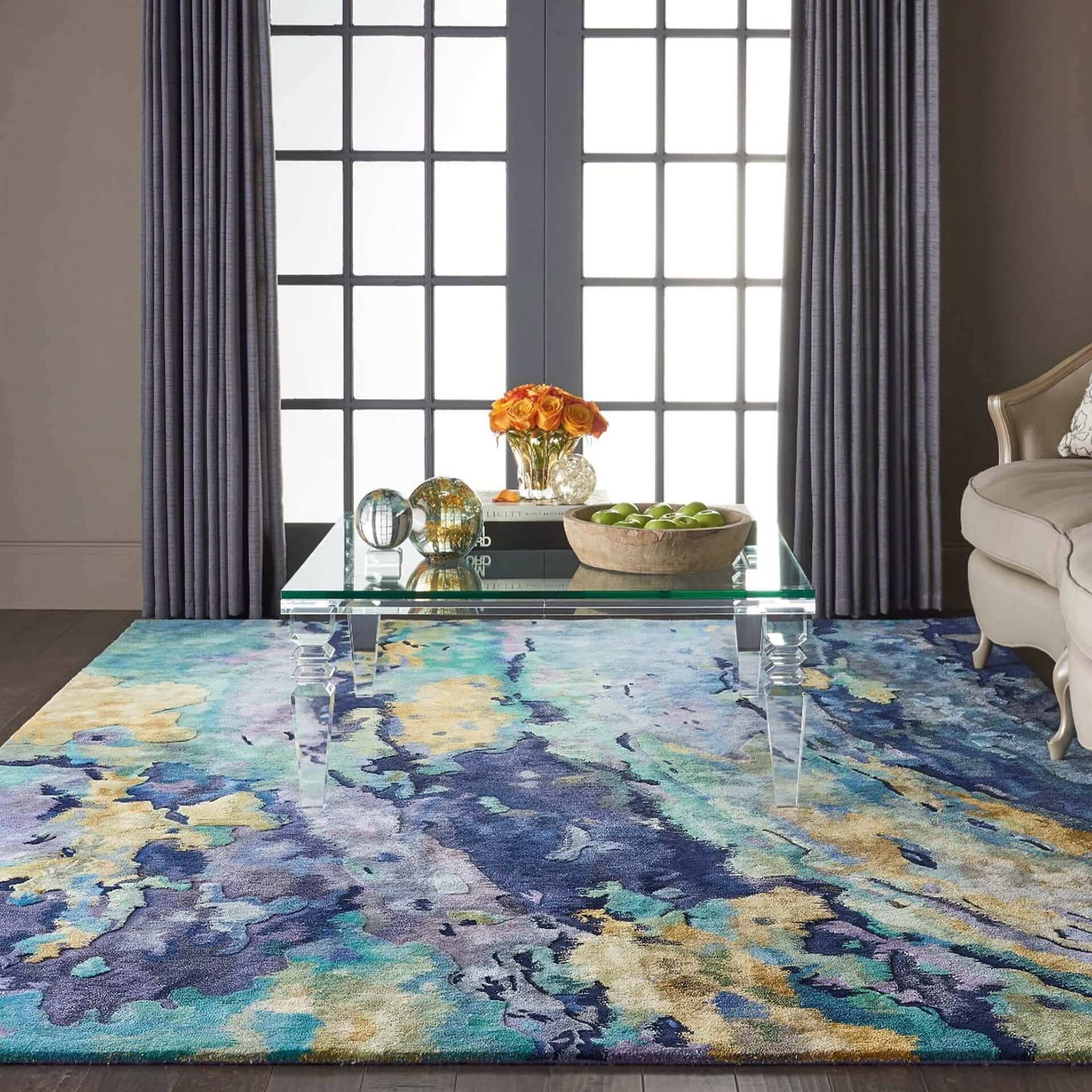 Elegant living room centerpiece with transparent acrylic furniture, colorful rug, and decorative accessories.