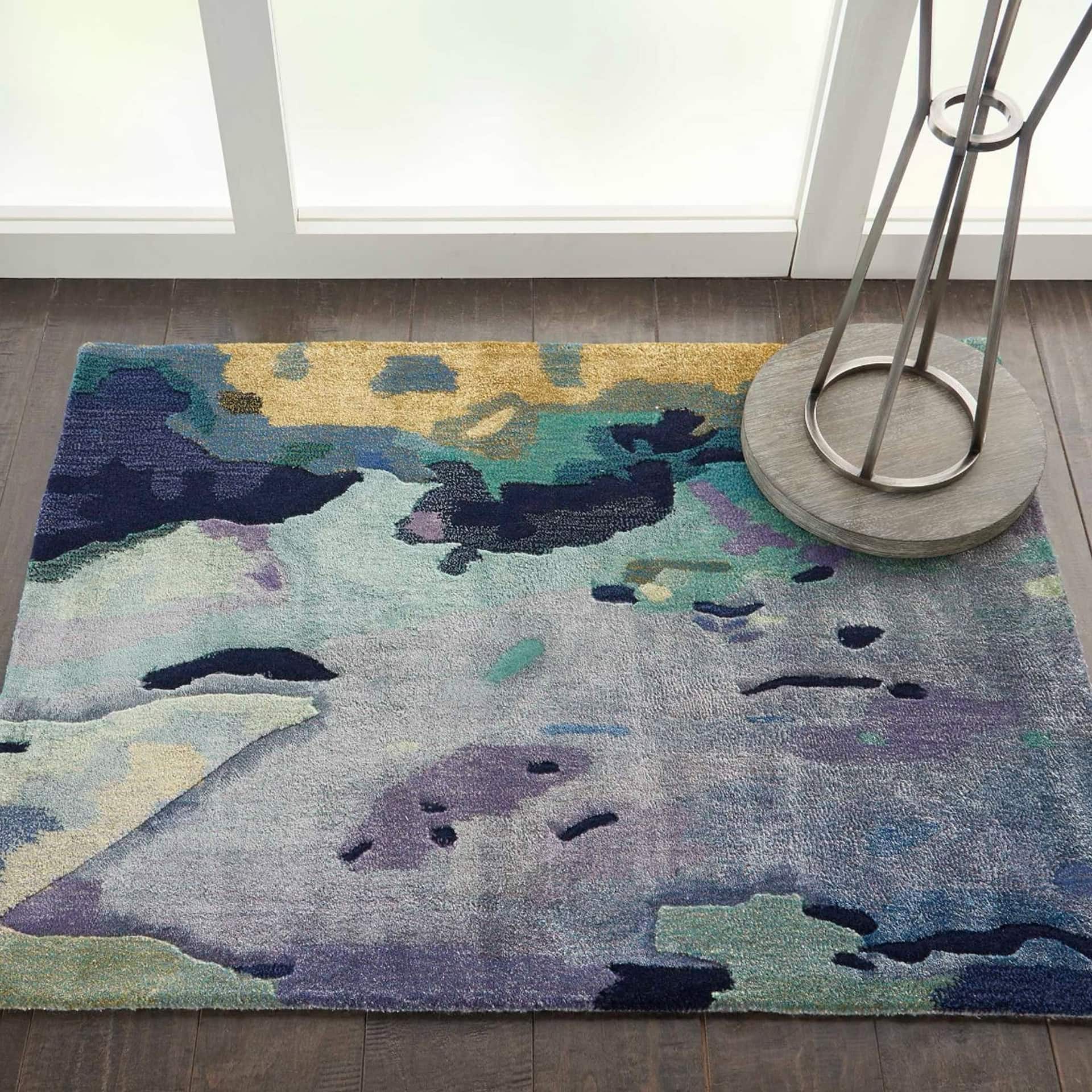 Colorful abstract area rug featuring a blend of blues, purples, and gold tones for contemporary interiors.