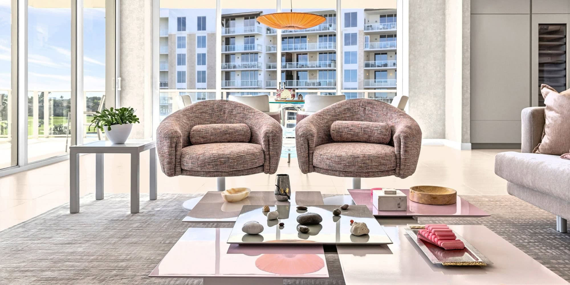 personalized-condo-from-top-to-bottom-case-study-1-1.7 Contemporary condo living room featuring cozy armchairs, a coffee table, and expansive city views th.