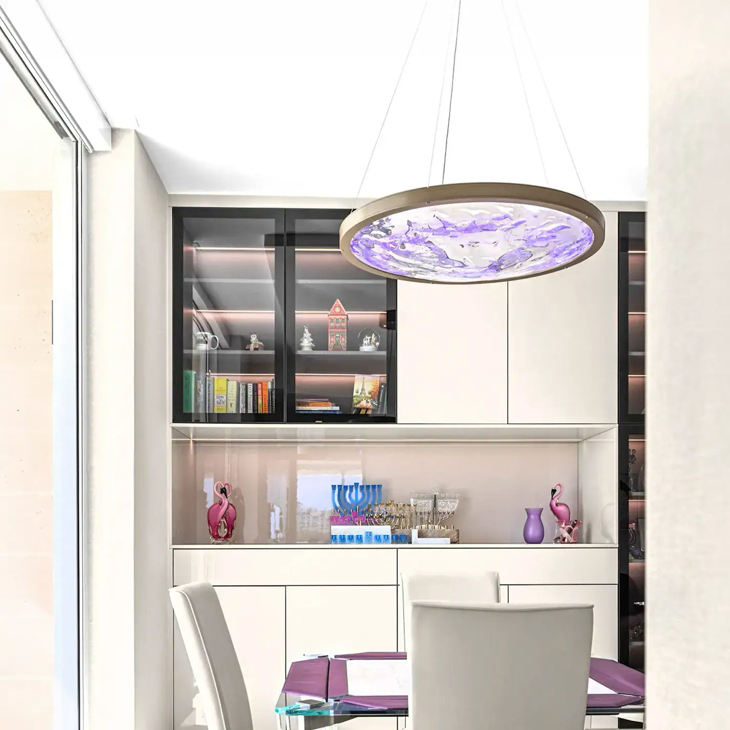 Bright modern condo dining space with sleek white furniture and vibrant decor accents.