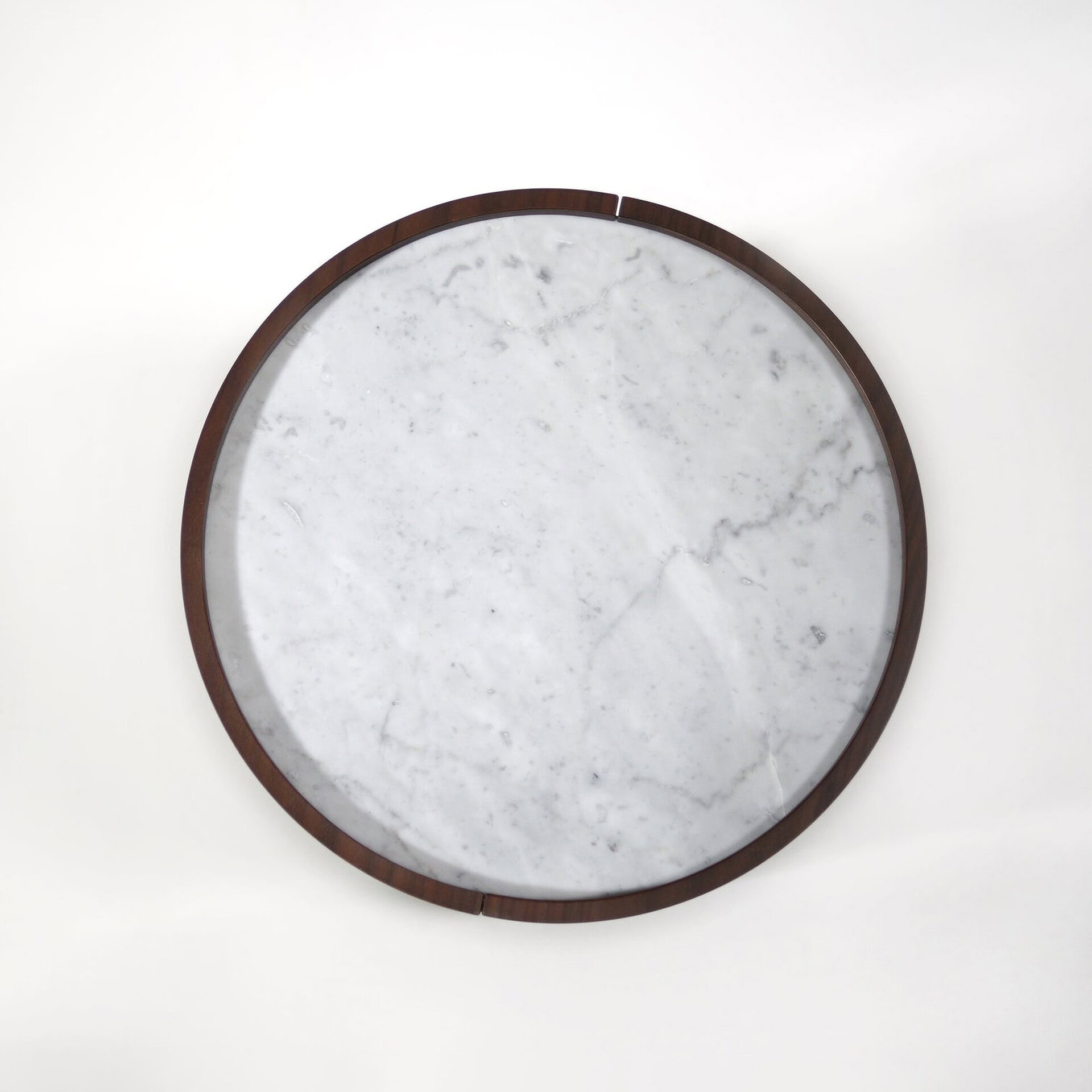 A round white marble tray with a dark brown wooden rim, viewed from above against a white background.