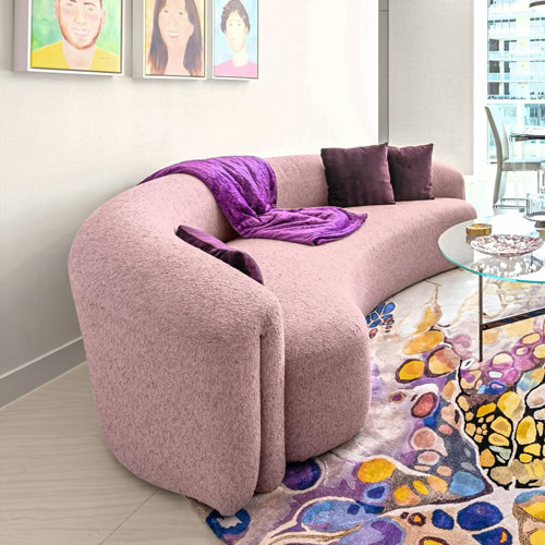 Modern pink sofa with purple cushions in a stylish condo living room.