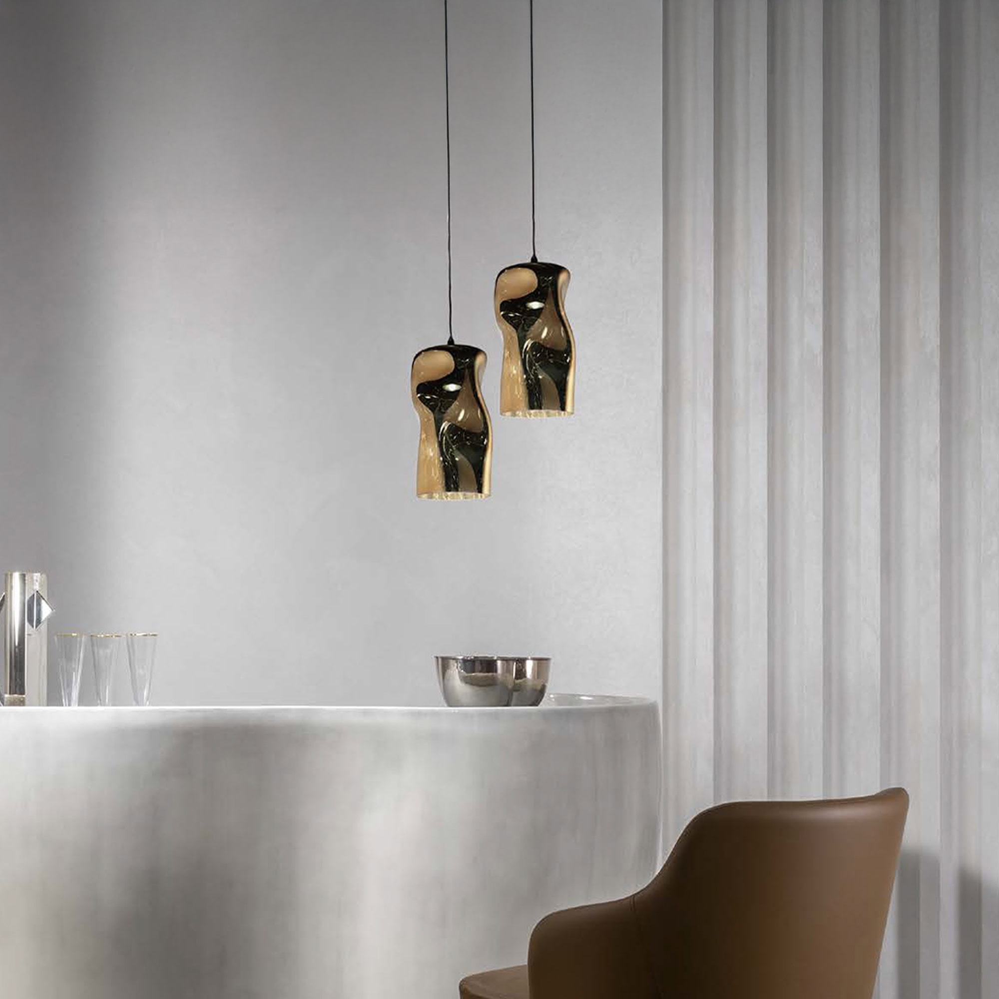Stylish brown leather chair with modern pendant lighting in a contemporary kitchen.