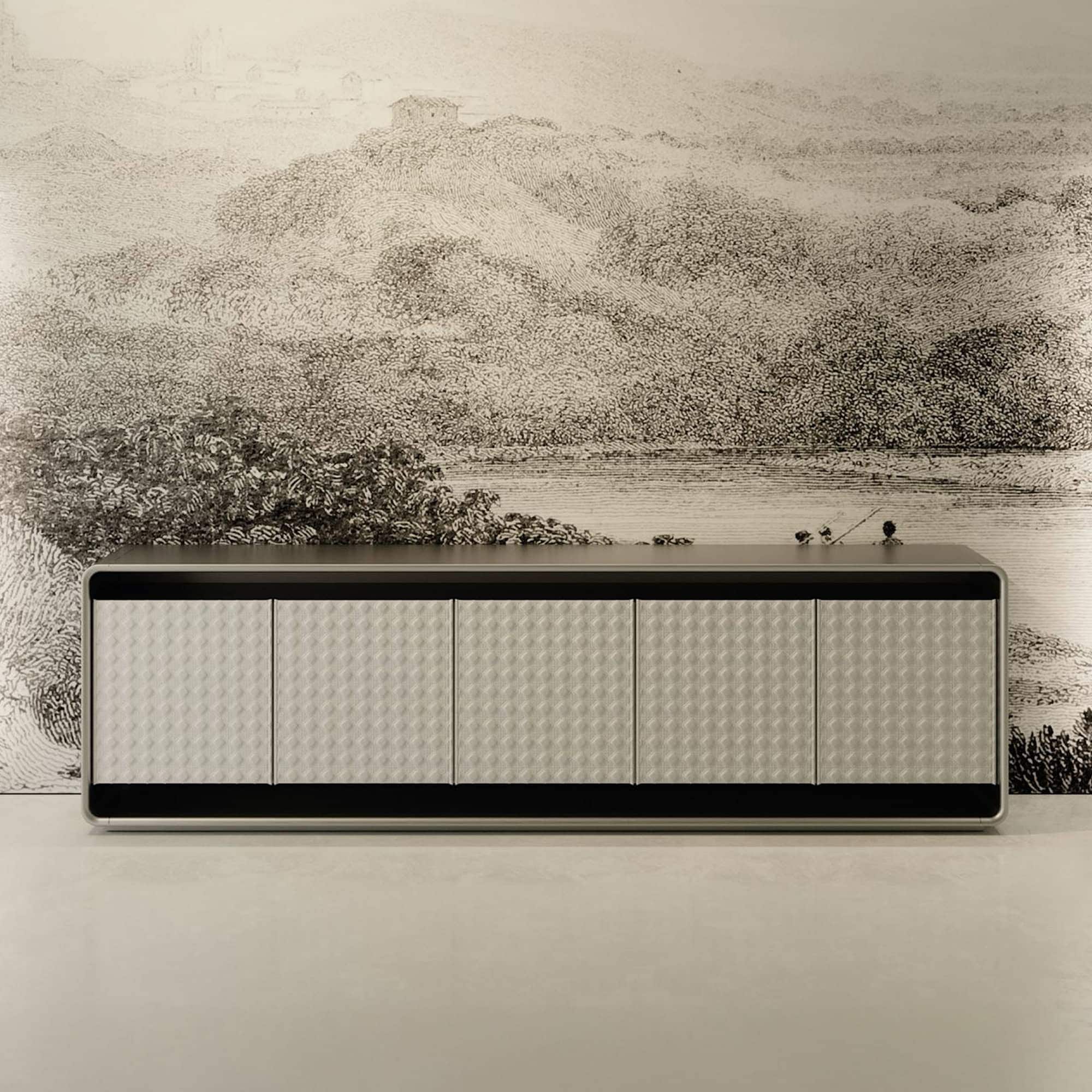 A modern, light gray sideboard with six textured, geometric-patterned doors. It is placed against a wall featuring a detailed black and white landscape mural depicting hills, trees, and a body of water.