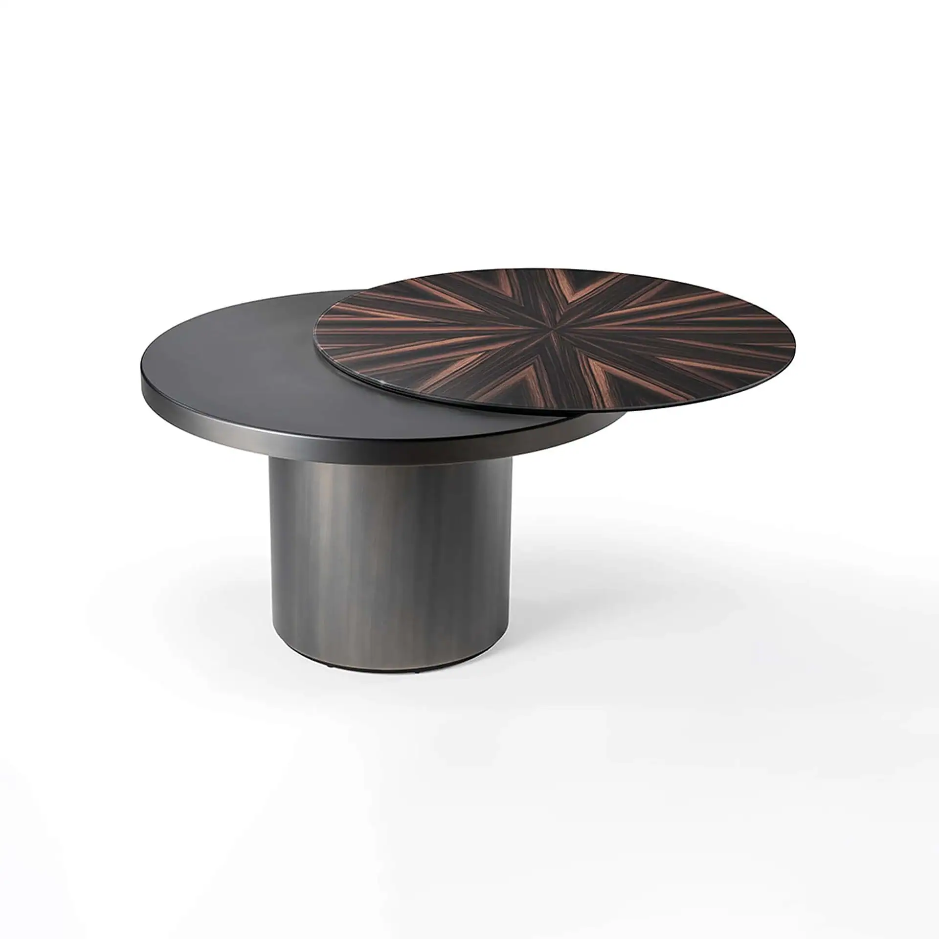 A modern round coffee table with a dark metallic cylindrical base and two circular tops. The lower top is dark gray, and the upper, smaller top features a starburst pattern of dark and reddish-brown wood veneers.