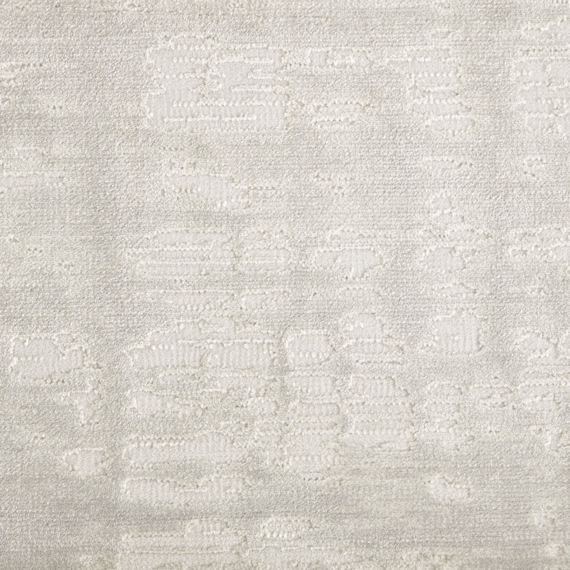 Close-up of a light beige or off-white textured fabric or carpet with a subtle, abstract tone-on-tone pattern.