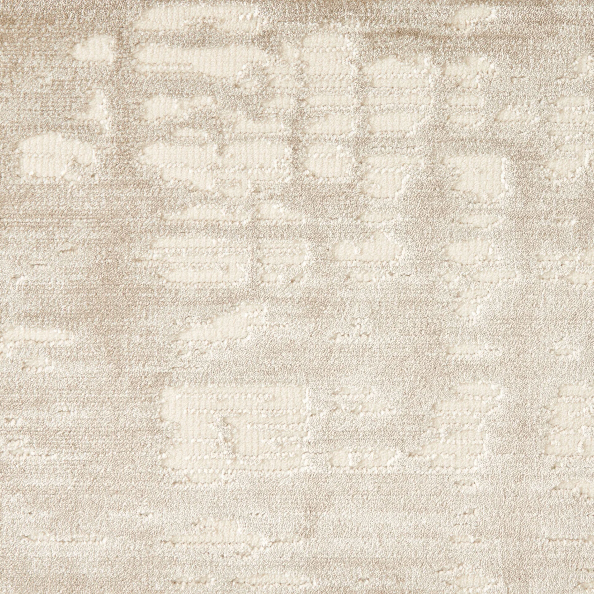 Close-up of a cream and light beige textured carpet with an abstract, organic pattern of irregular shapes.