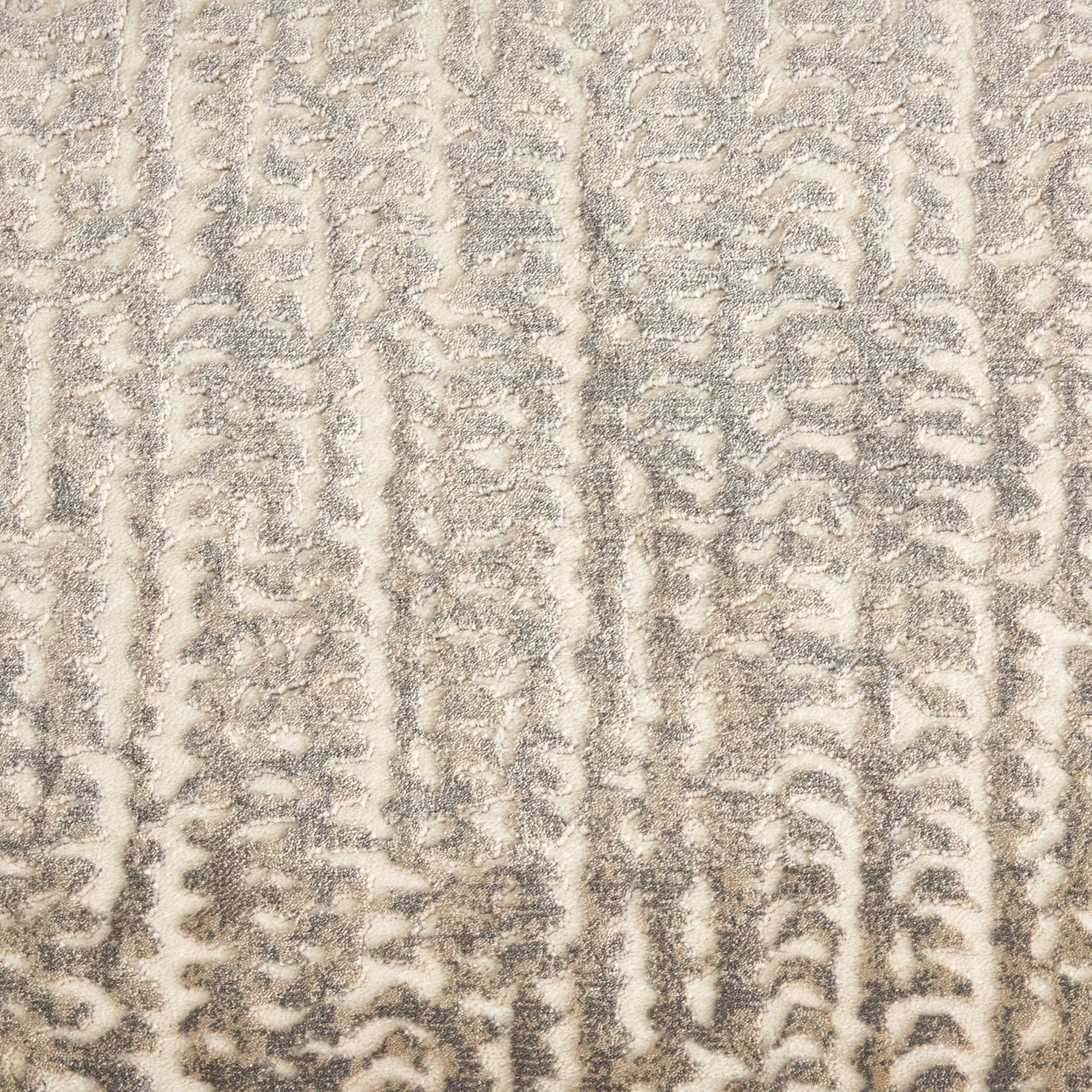 Detailed close-up of a textured beige and gray patterned rug for living room decor.