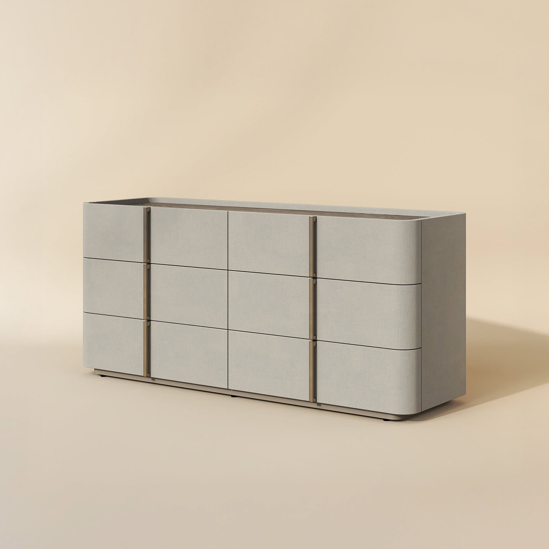 A modern light grey dresser with rounded corners and vertical brass-toned handles, set against a warm beige background.