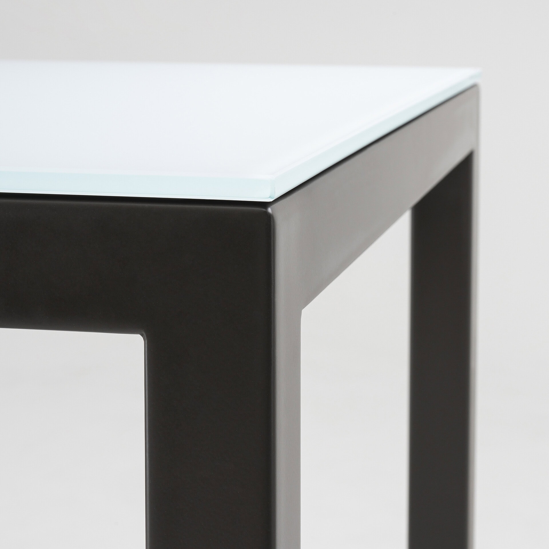 Elegant black table with a tempered glass top, perfect for contemporary interiors.