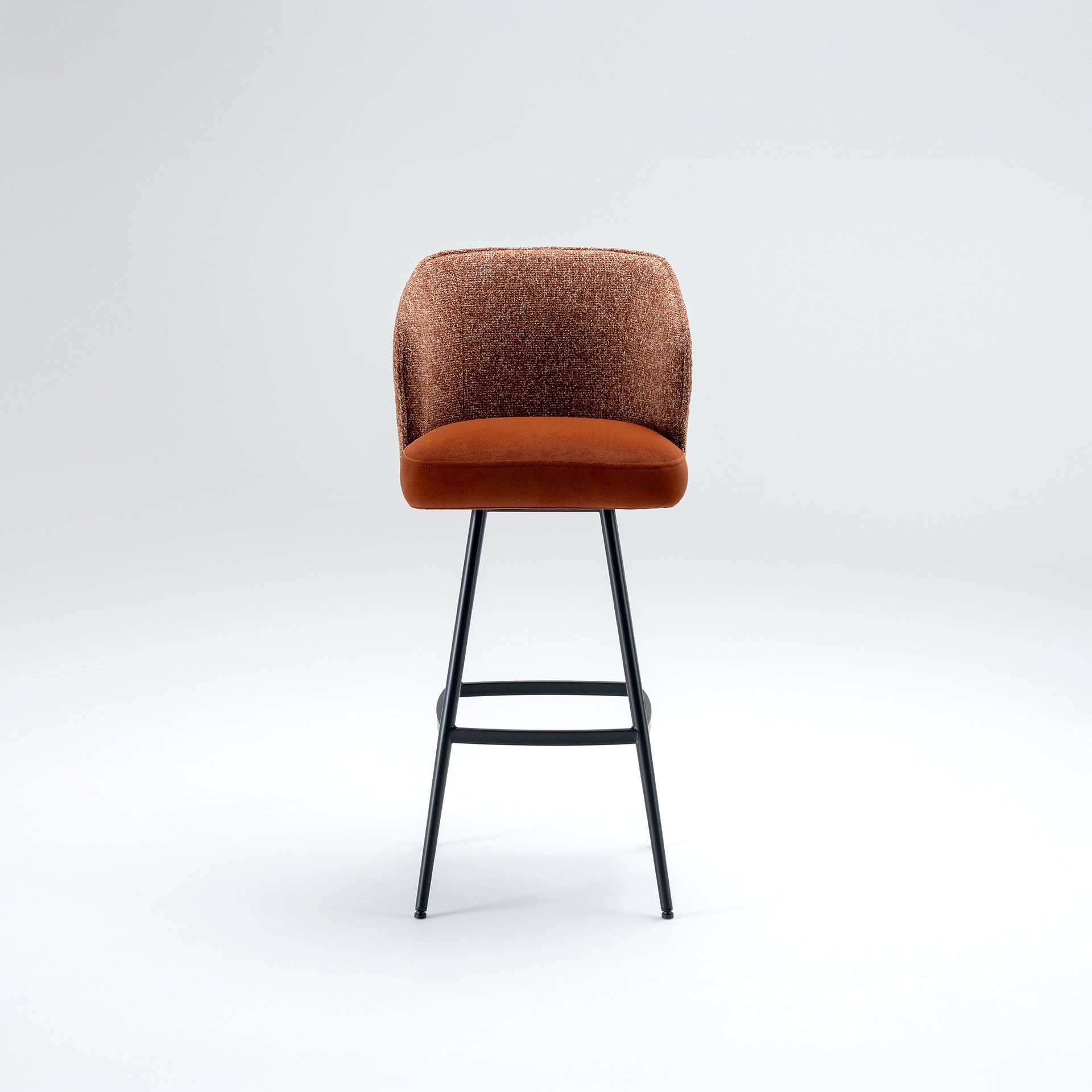 Front view of a modern bar stool with a textured burnt orange backrest, a plush orange seat, and slender black metal legs, set against a light grey background.